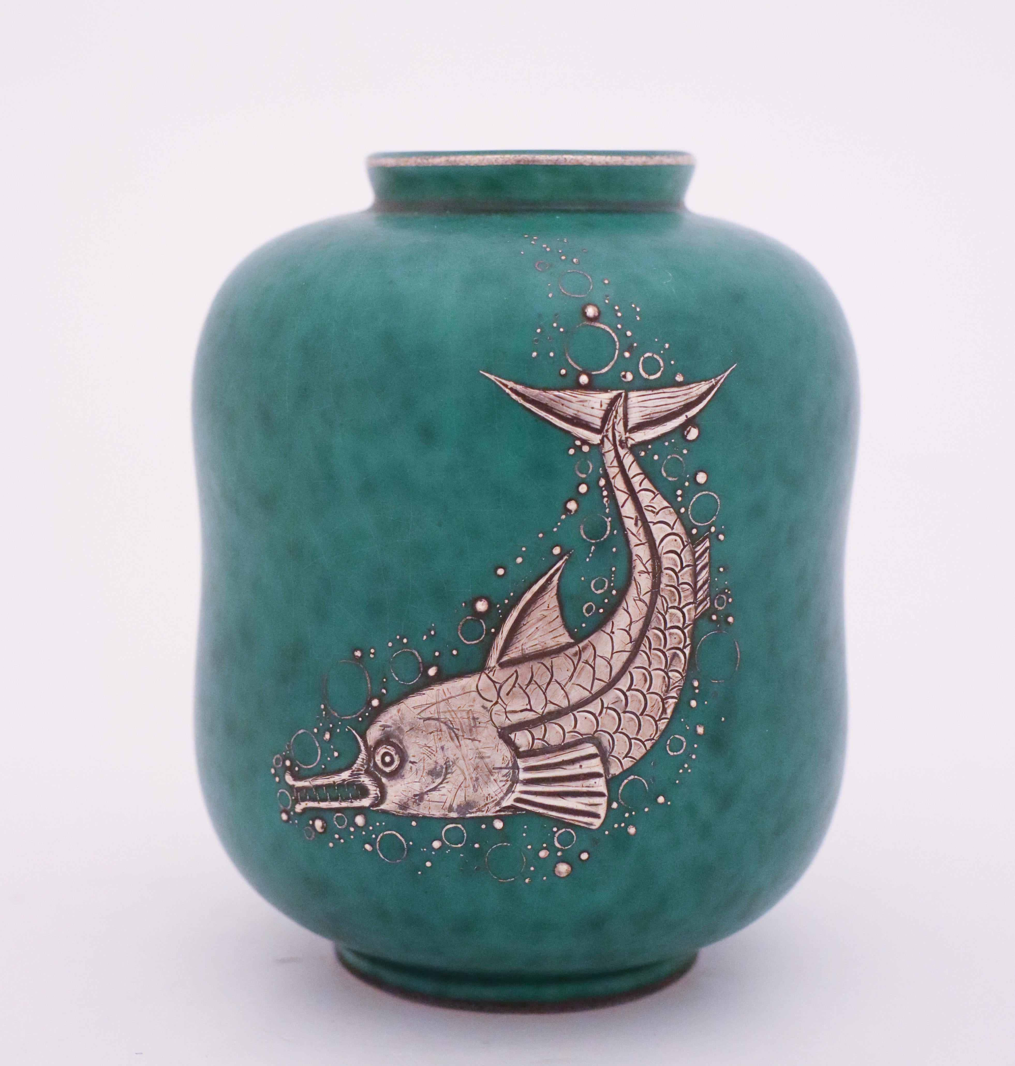 A vase in stoneware of model Argenta designed by Wilhelm Kåge at Gustavsberg with silver decor of a fish, this vase is 12.5 cm high and 9.5 cm in diameter. It´s in mint condition and marked as on photo.