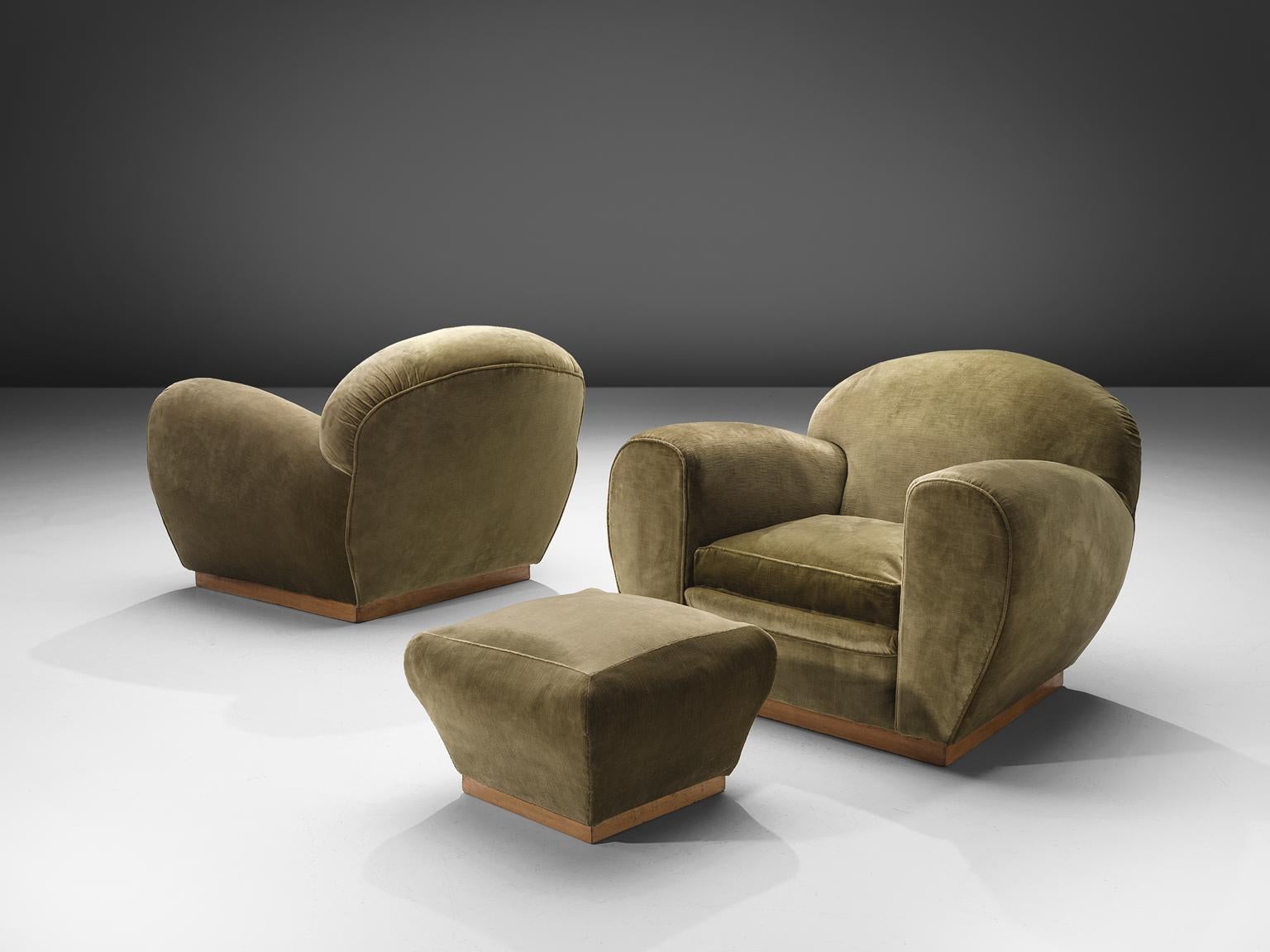 Lounge chairs and ottomans, green velvet fabric, Italy, 1940s. 

Wide and comfortable chair in green velvet fabric upholstery. Truly extraordinary luxurious lounge chairs that features a very deep seat and rounded, curved armrests. This piece is as