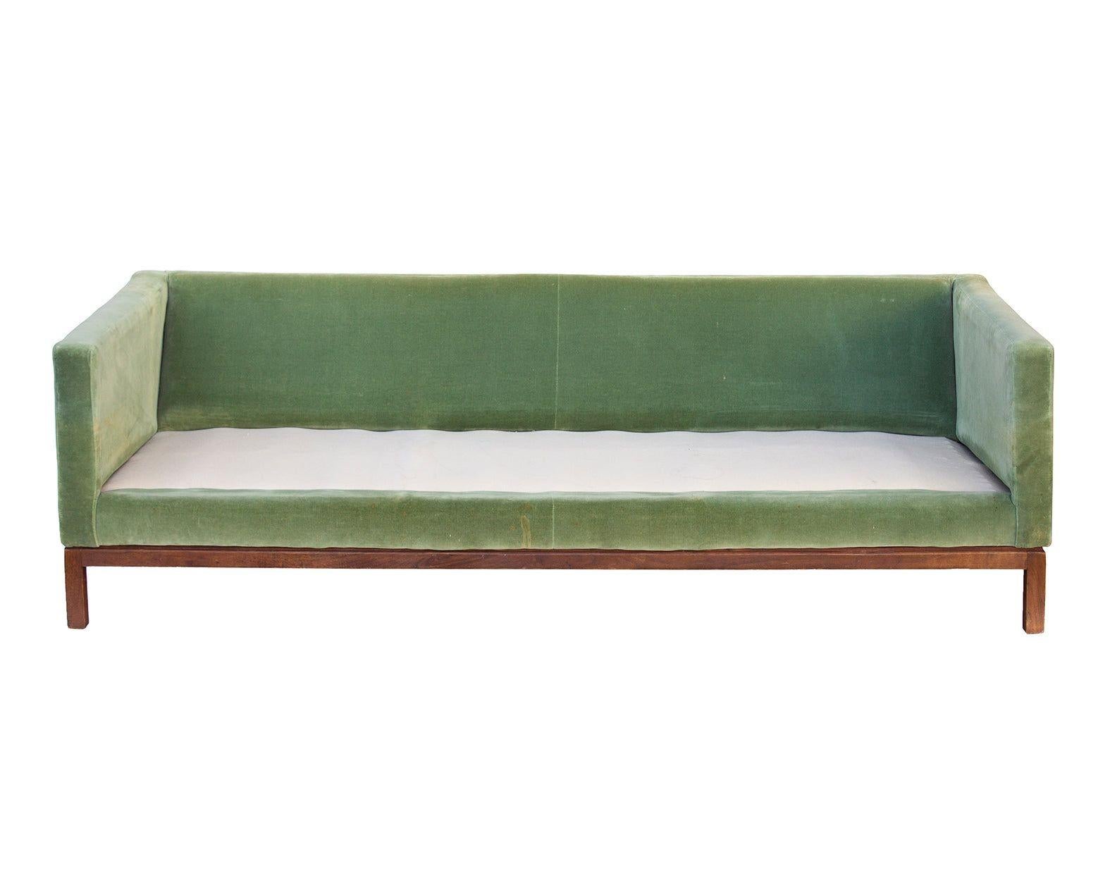 USA, 1960s
Green cotton velvet sofa with a square, solid walnut base. Great profile. 
CONDITION NOTES: Reupholstery recommended as fabric has stains and losses to the velvet. Base has been repaired nonprofessionally at back right corner leg as