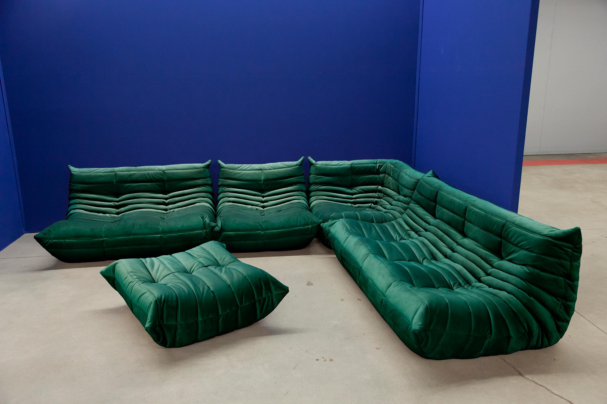 This Togo living room set was designed by Michel Ducaroy in 1974 and was manufactured by Ligne Roset in France. Each piece has the original Ligne Roset logo and genuine bottom. It has been reupholstered in genuine high quality bottle green velvet
