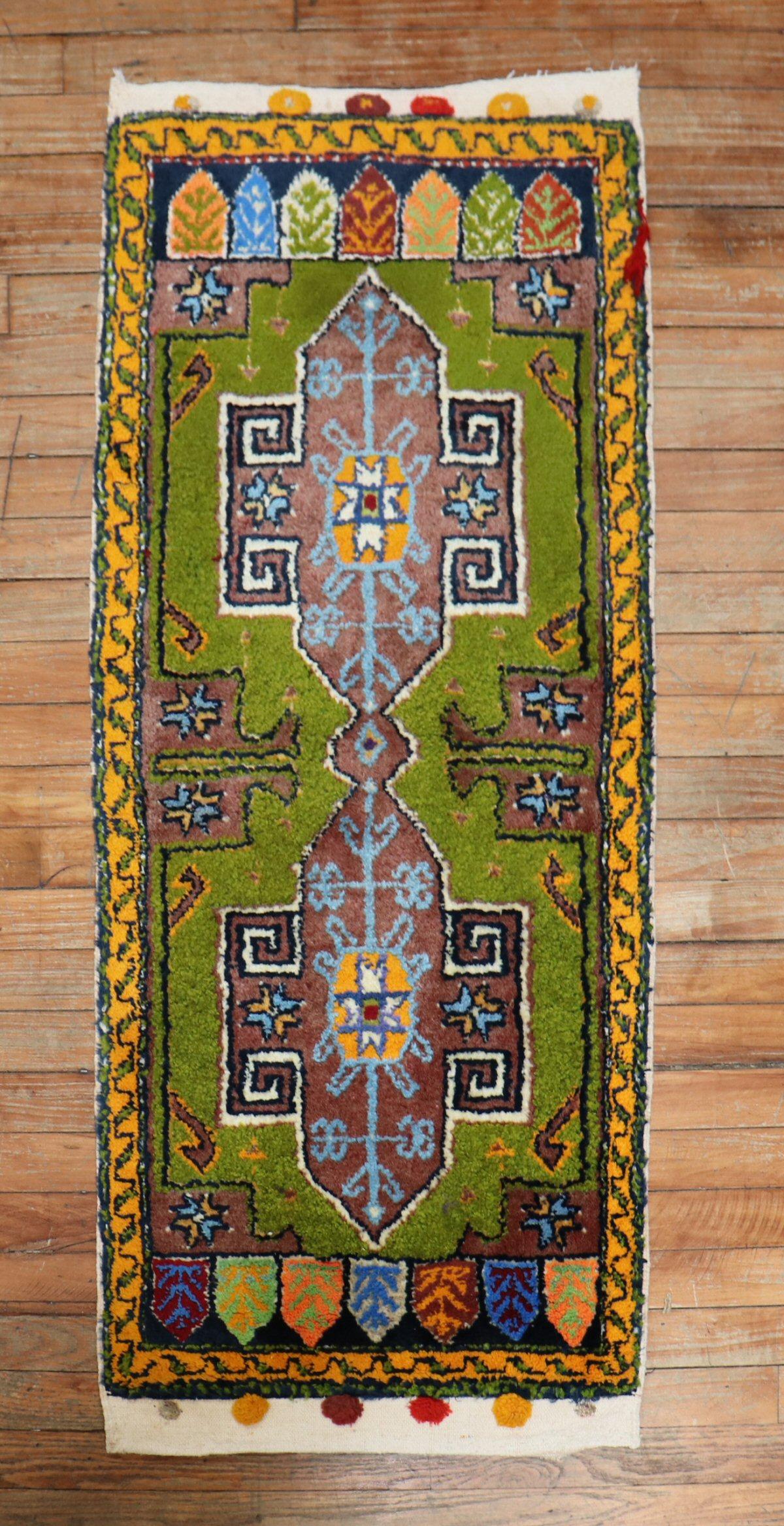 A vintage Anatolian Turkish Yastik rug mat featuring a pea green field

1'11'' x 4'3''