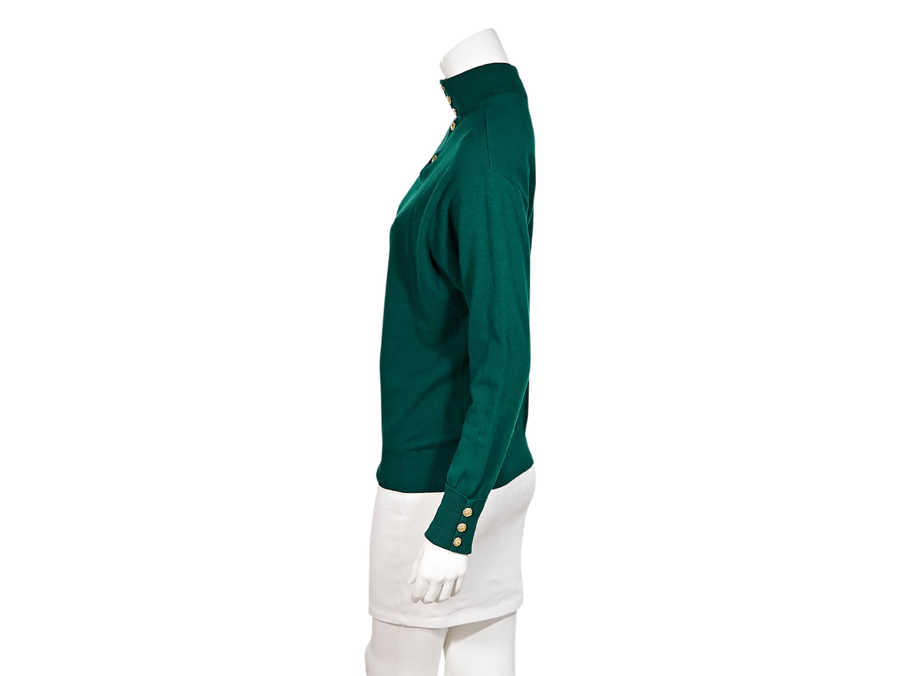 Product details:  Vintage green cashmere sweater by Chanel.  Ribbed mock neck.  Long sleeves. Ribbed cuffs with three-button detail.  Button-front placket.  Pullover style.  Goldtone hardware.  Label size FR 40.  40
