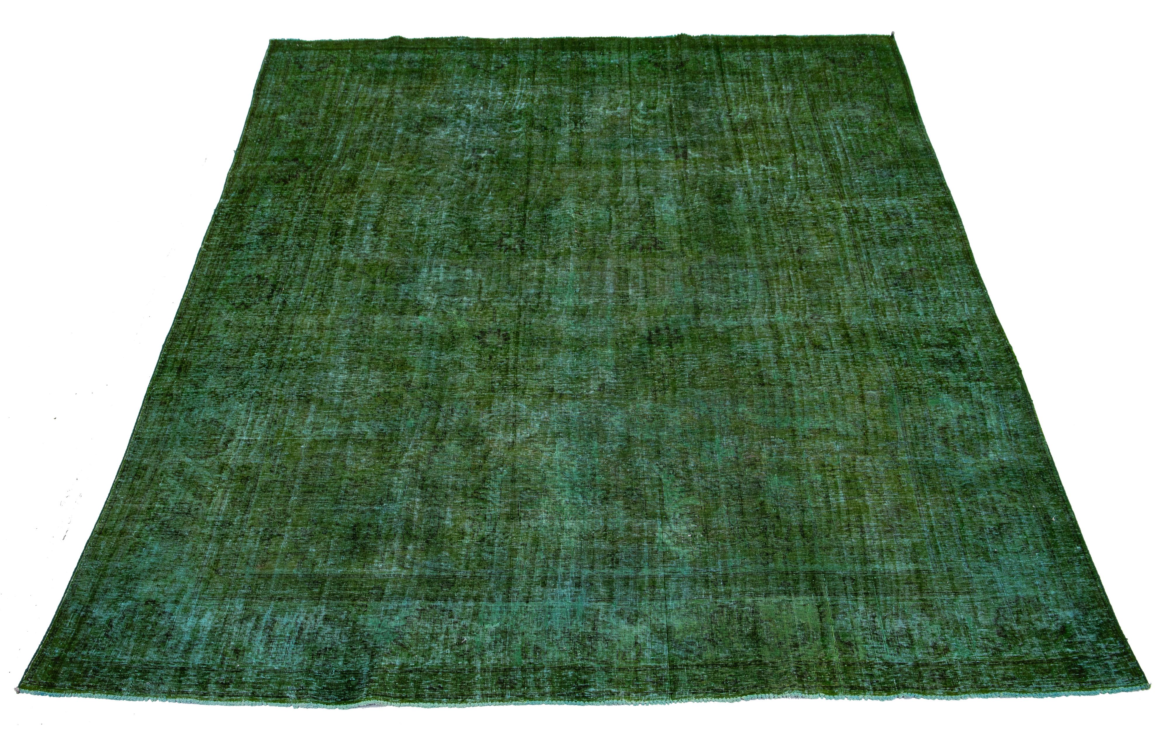 Beautiful Vintage overdyed hand knotted wool rug with a green field. This Persian rug has brown accents in an all-over design.

This rug measures: 9'8'' x 12'11