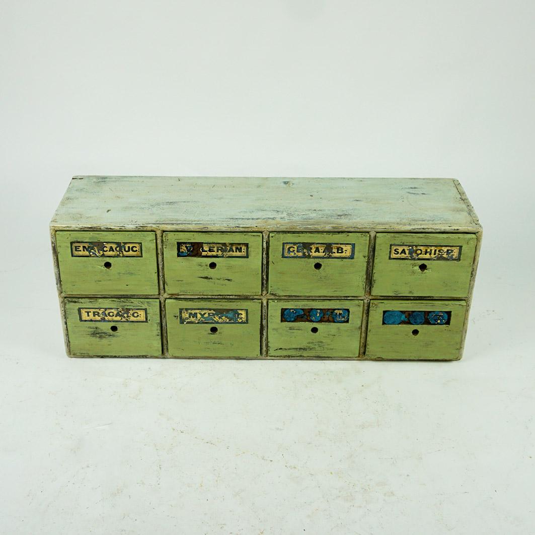 Amazing green industrial wooden Apothekary cabinet or chest with 8 drawers with original glass plates which show the names of the medicines which was stored inside.
This charming vintage cabinet is in very nice original condition with some wear and