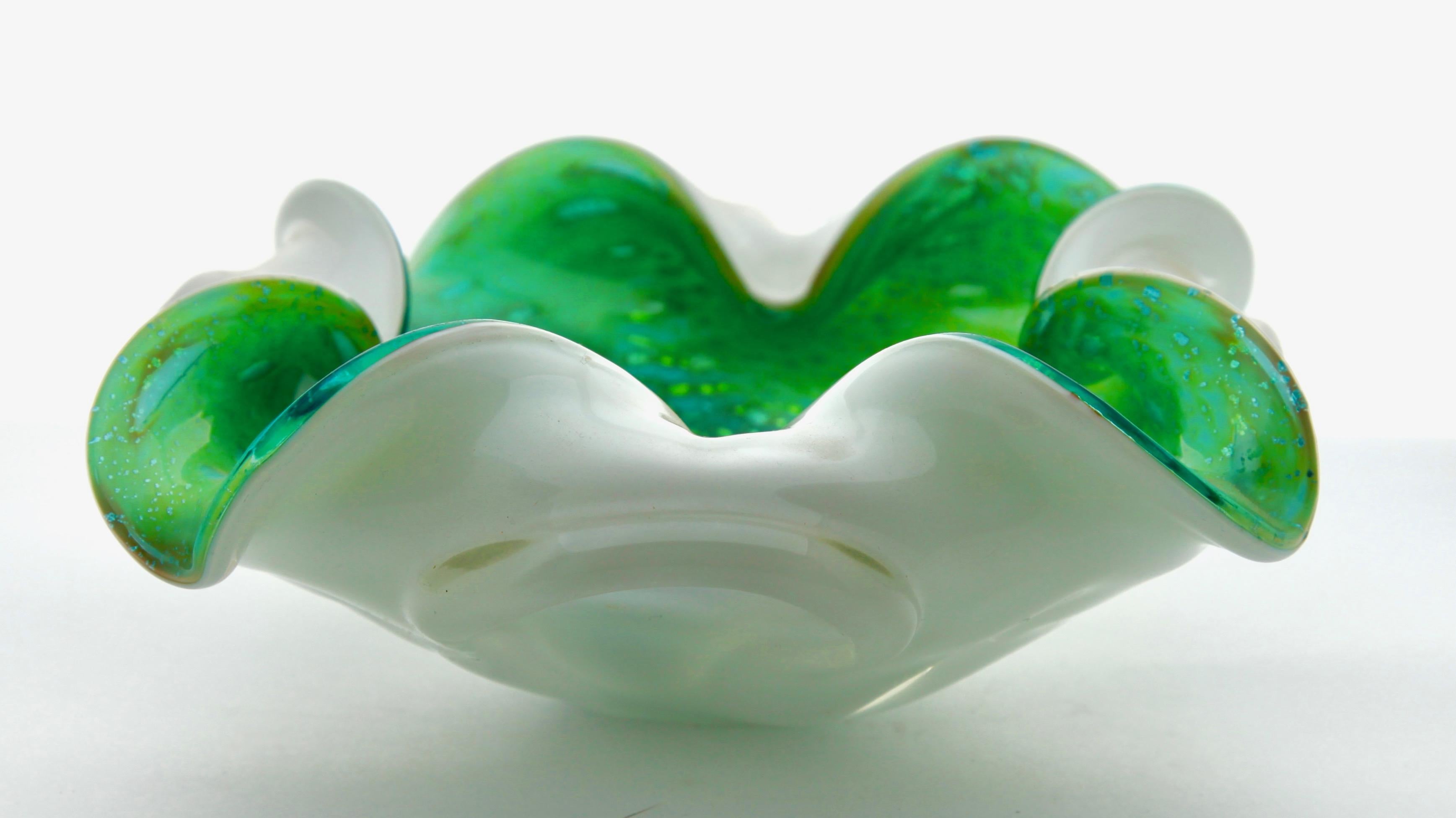 Four-lobed shell bowl with opaline casing.
In the Seguso style, this biomorphic four-lobed Murano glass bowl is handcrafted with an inner bowl in bright green and cased in an opaque white (opaline) casing, the controlled bubbles swirl up from the