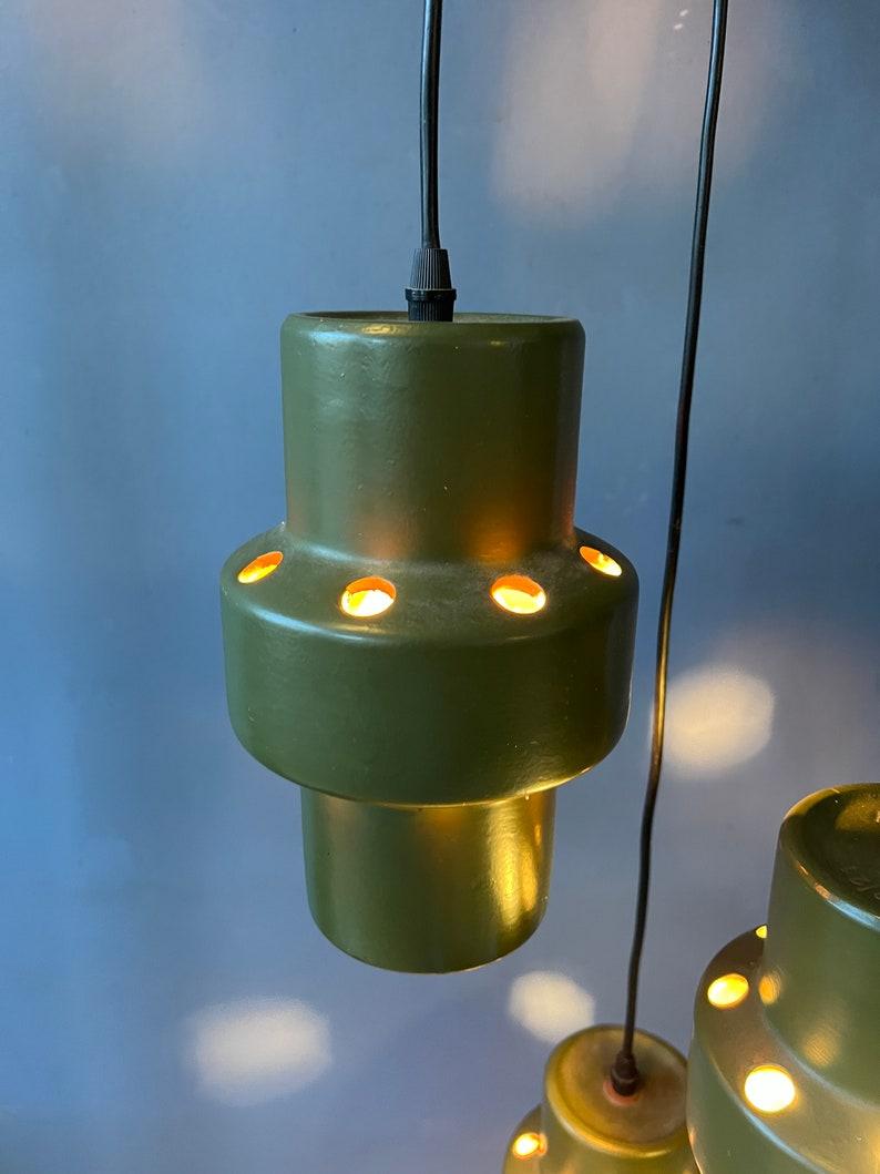 Lampe chandelier cascade verte d'Allemagne de l'Ouest avec trois lampes en céramique. La hauteur de chaque lumière individuelle peut être facilement ajustée, les photos ne montrent qu'un exemple. La lampe nécessite trois ampoules E14.

Informations