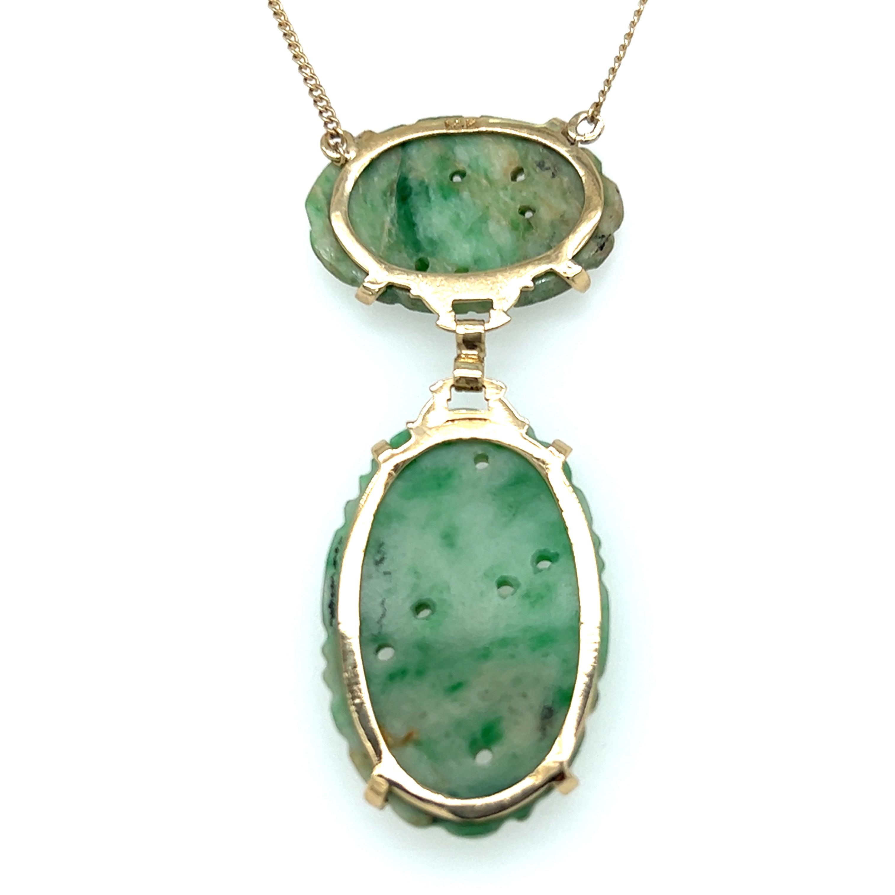 Eine Kordelkette aus 14 Karat Gelbgold (gestempelt 14K), die mit zwei geschnitzten hellgrün/weißen ovalen Jadesteinen verbunden ist.  Die Kette ist 20 Zoll lang und mit einem Federringverschluss versehen. Die Halskette wiegt insgesamt 8.8 Gramm.  