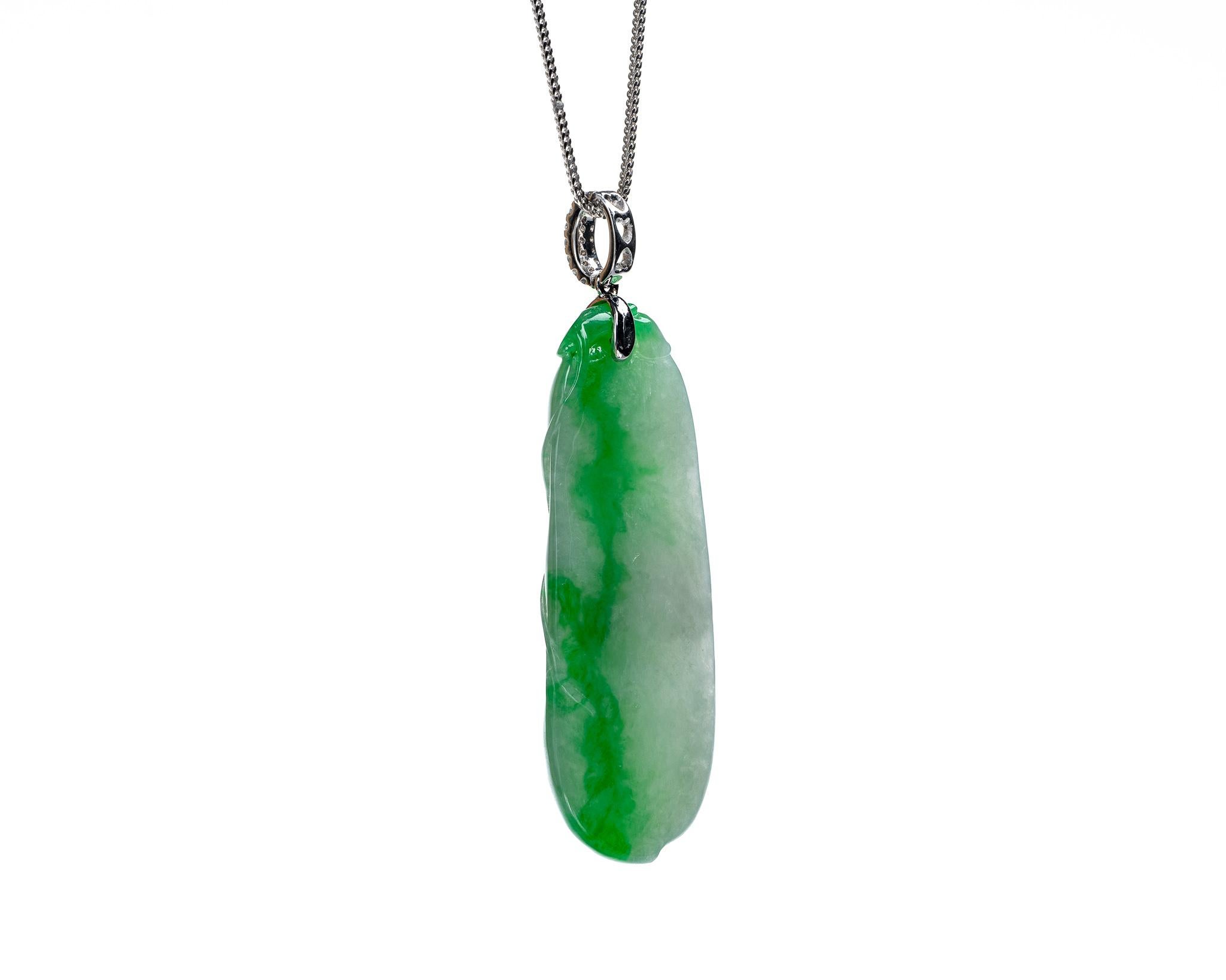 This is an all natural, untreated jadeite jade carved peapod pendant set on an 18K white gold and diamond bail.  The carved peapod represents happiness, prosperity and longevity. 

It measures 0.81 inches (20.5 mm) x 2.05 inches (52.1 mm) with