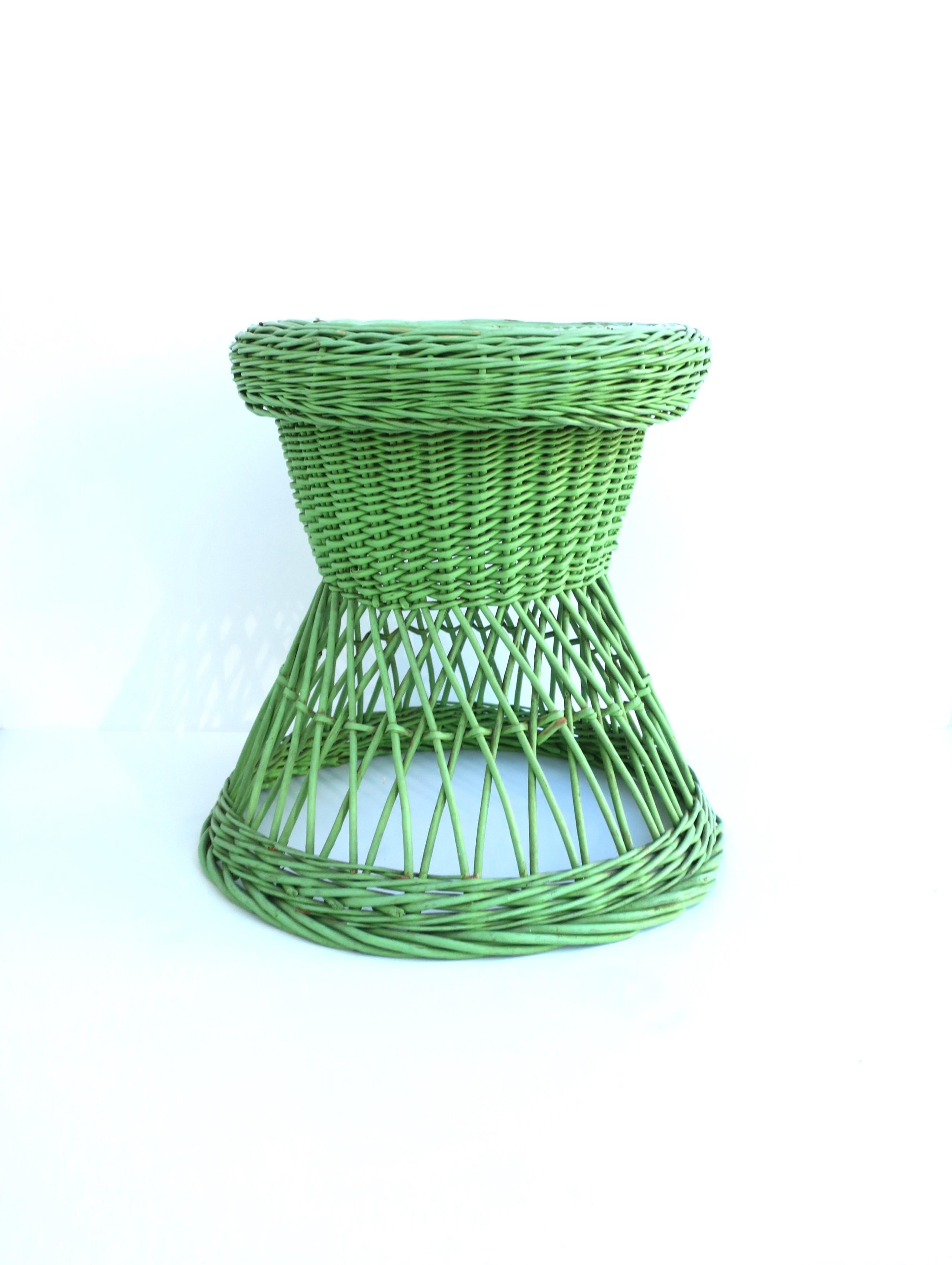 A pistachio green wicker stool with hourglass shape, circa early to mid-20th century. A pistachio green wicker stool or side/drinks table, plant stand, etc., many uses. It appears that color/paint was professionally applied. Piece is a convenient