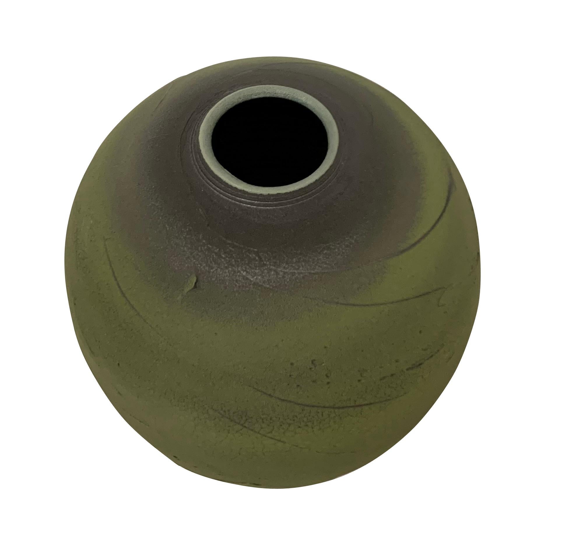 Contemporary textured ceramic earthenware vase.
A large, classic shaped textural green body with grey that appears to be air brushed at the top opening and bottom of the vase.
The vase design has an ancient feel.
Hand made one of a kind.
Part of