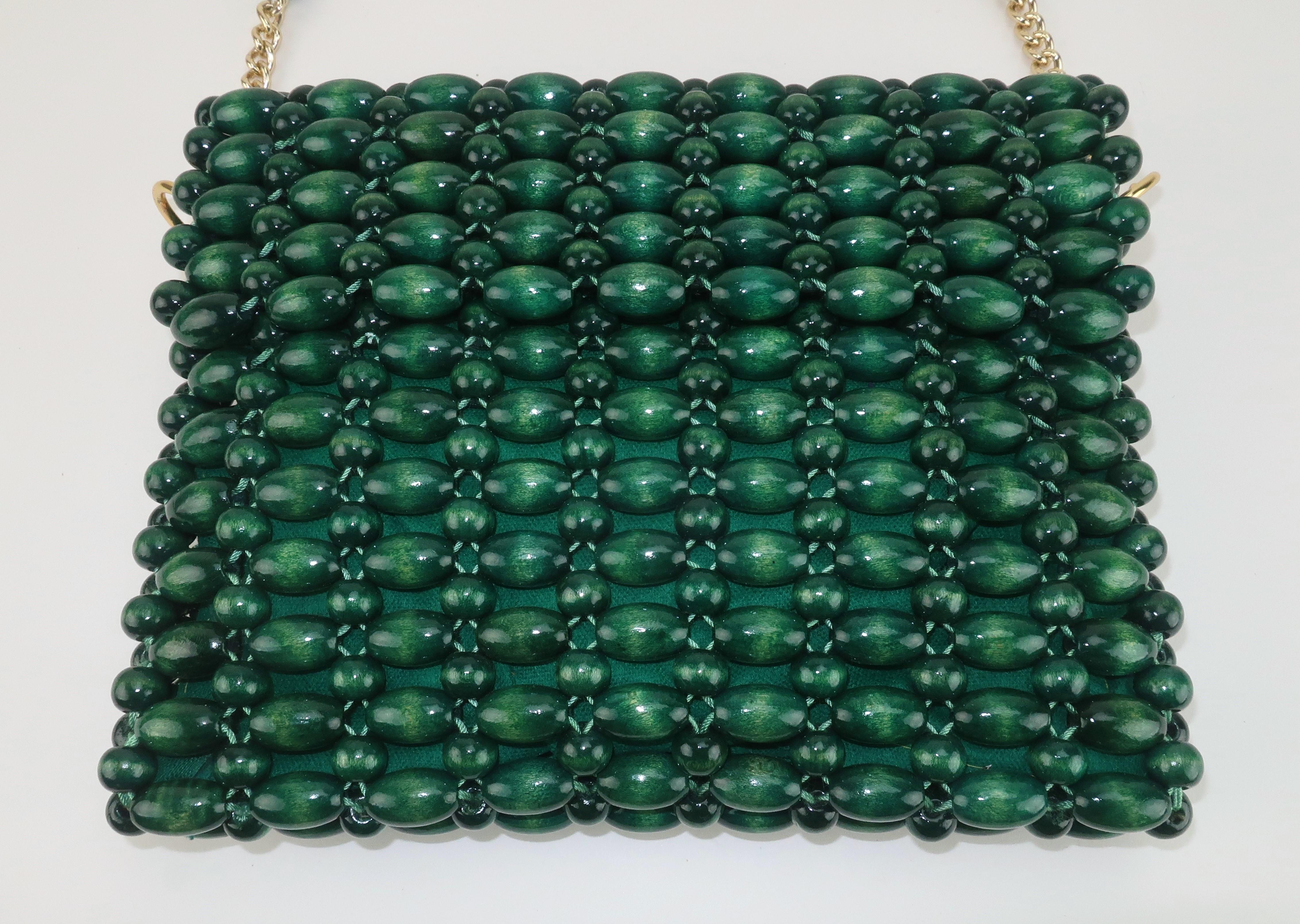 Sac à main moderne des années 1960 en perles de bois d'un riche vert émeraude.  La poignée à hauteur d'épaule est ornée de chaînes dorées pour apporter une petite touche de glam à ce look par ailleurs bohème chic.  Le rabat avant se retourne pour