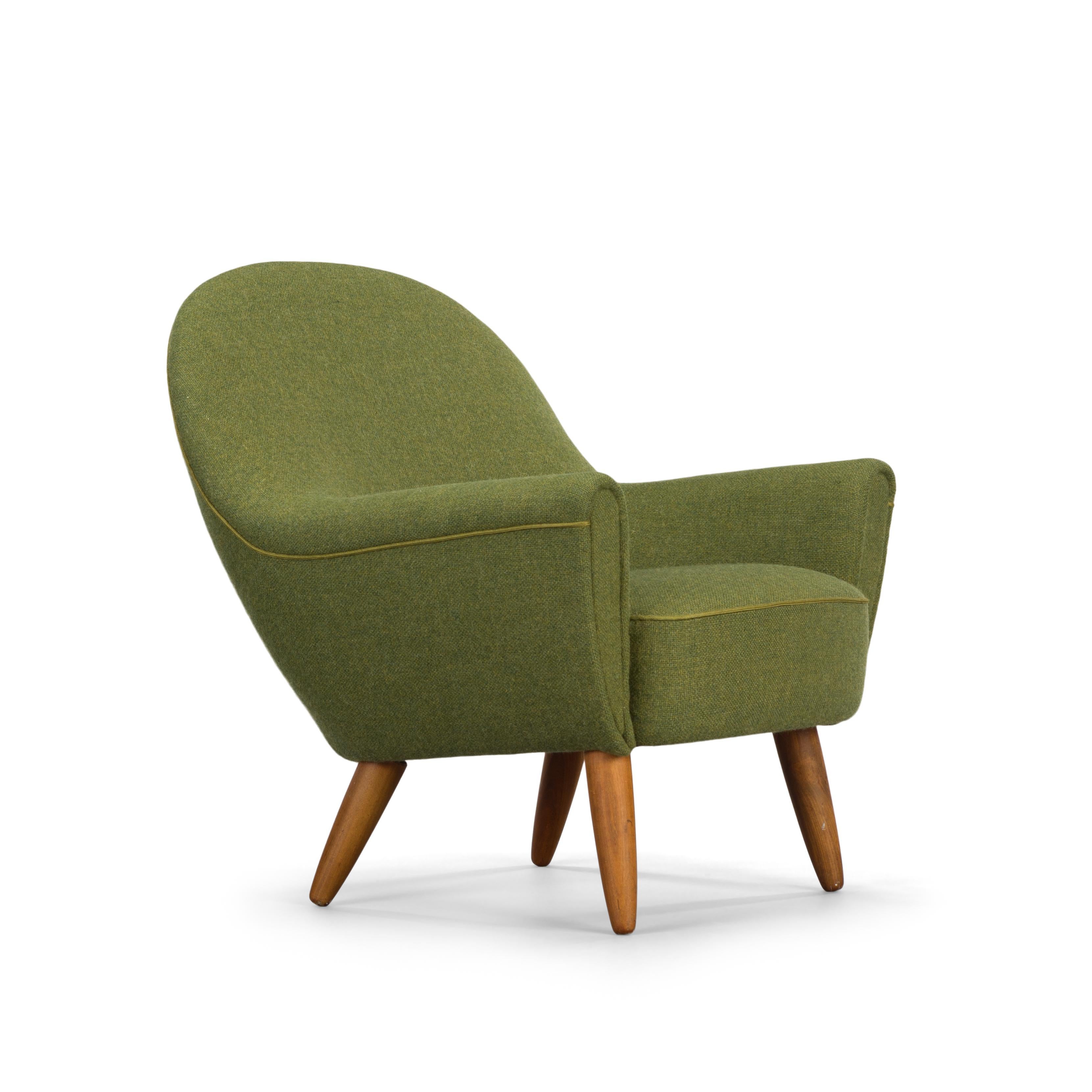 This comfy lounge chair slash cocktail chair has been designed by Johannes Andersen for CFC Silkeborg. The fabric on the chair is fully original and in remarkably good shape. The recognizable Andersen design style of the chair front was used