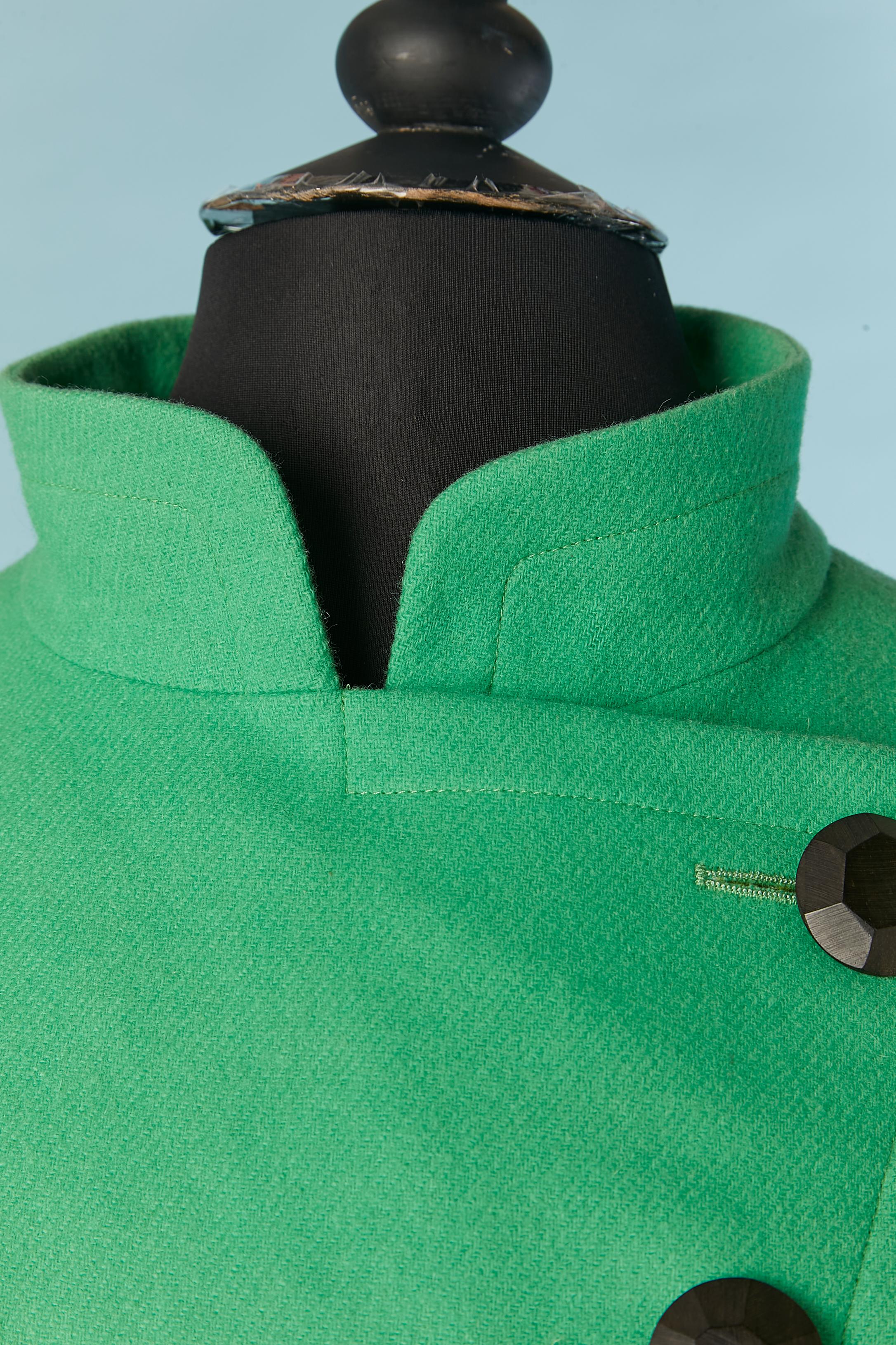 Zweireihige grüne Wolljacke mit Ledergürtel und Lederschleife. Kein Etikett für die Stoffzusammensetzung, aber das Futter ist wahrscheinlich aus Acetat oder Viskose. 
2 zusätzliche Tasten werden mitgeliefert. 
Größe 36 (Fr) auf dem Etikett, passt