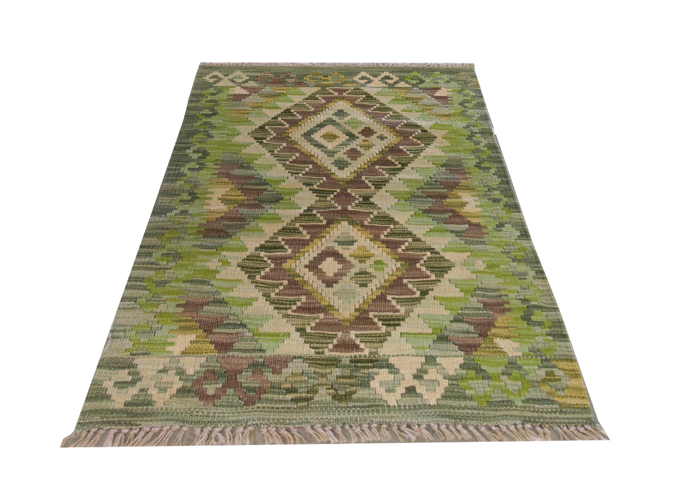 This fine wool kilim was woven by hand in Afghanistan. The design is bold and vibrant, interspersed with two large geometric medallions in brown, green, and beige accents. The colour palette and design make it the perfect accent piece for any home.