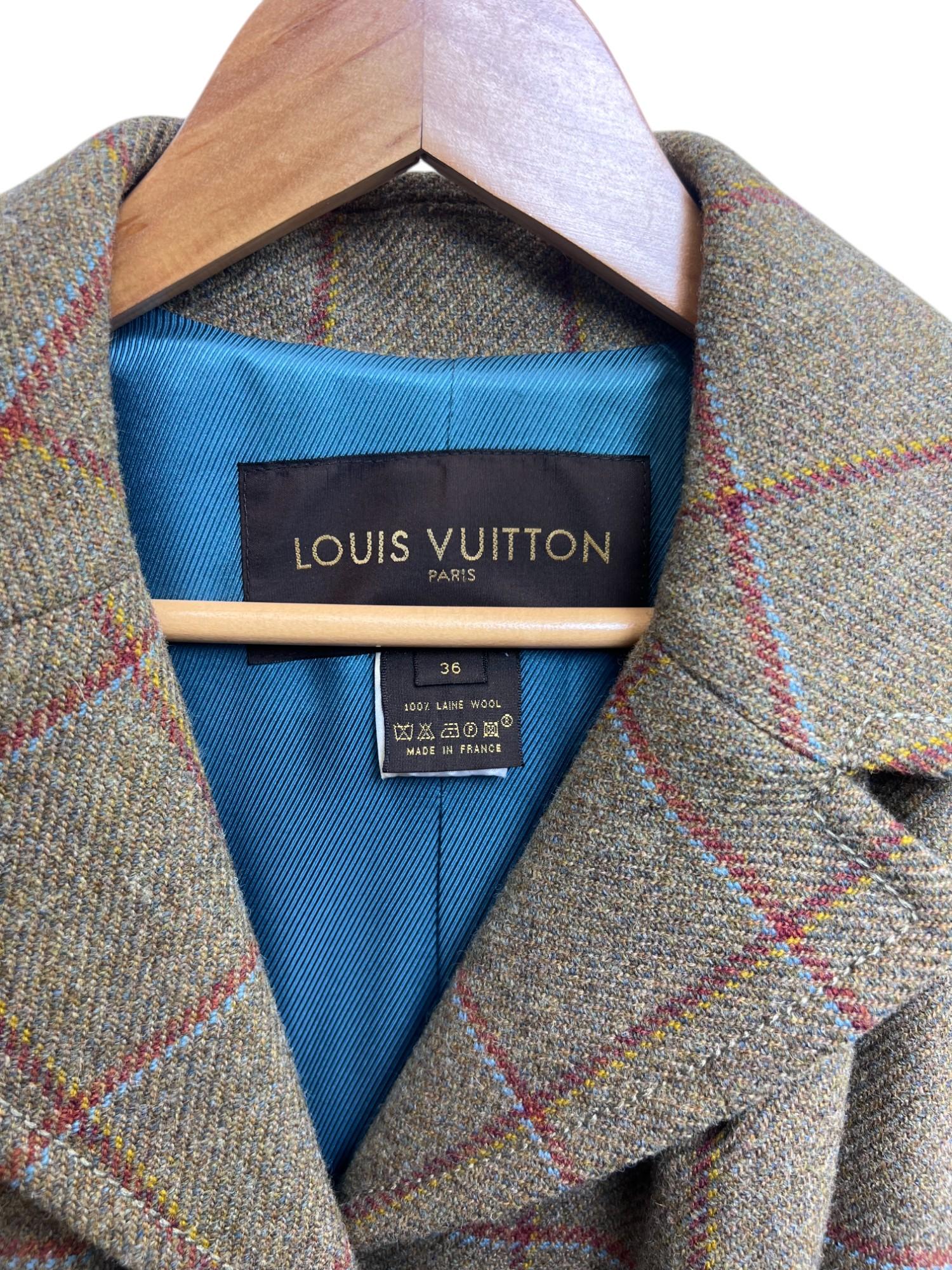 A timeless and impeccably tailored green wool plaid coat, expertly crafted in France. Designed with a classic notched collar and a hidden button closure, this elegant piece offers a sleek and polished silhouette. The slightly flared hem adds subtle