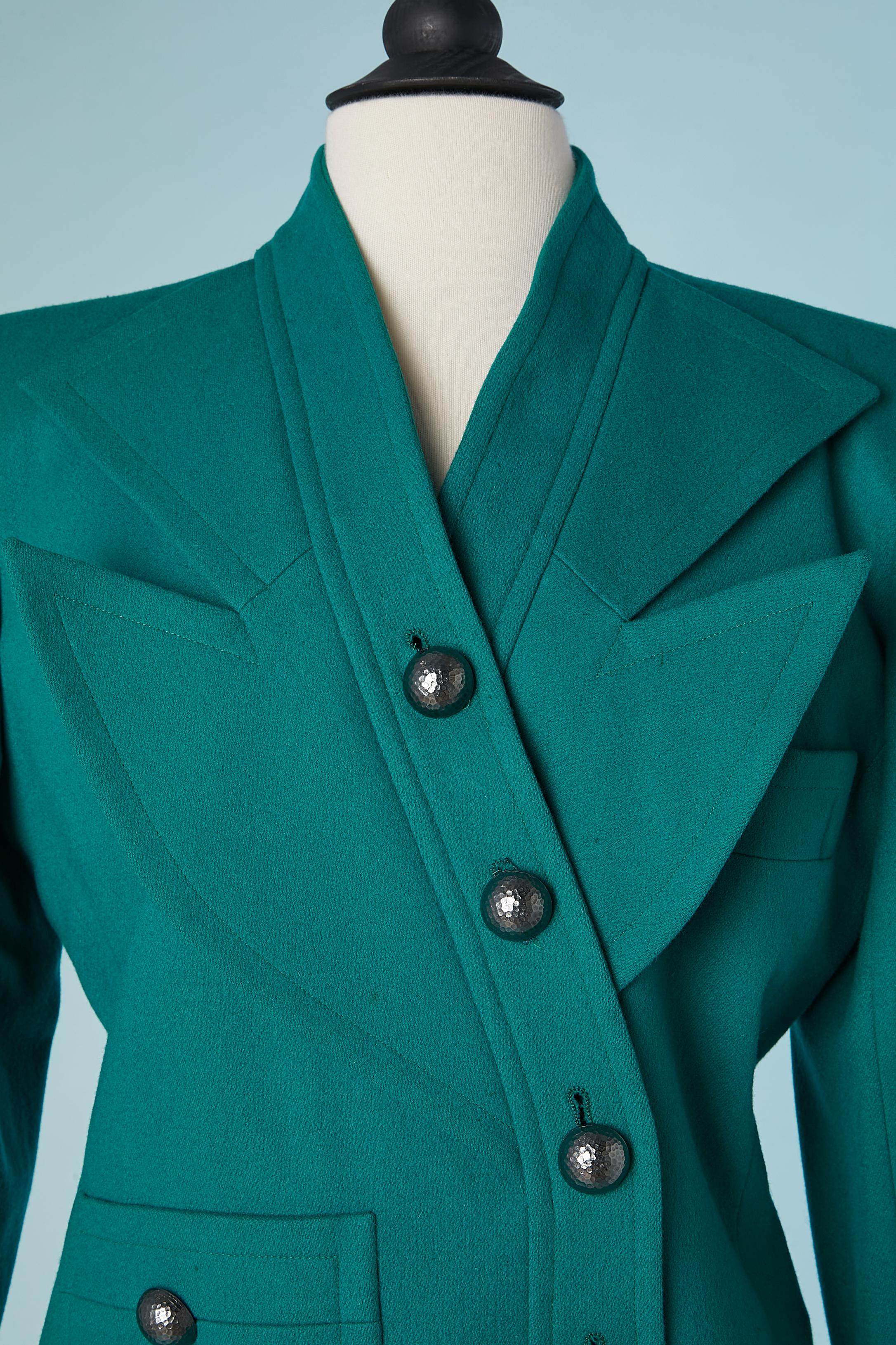 Green wool skirt-suit with graphic collar. Double-breasted jacket and hammered metal buttons. Shoulder-pad. Silk lining.
Size 38 ( jacket) and 40( skirt) 
