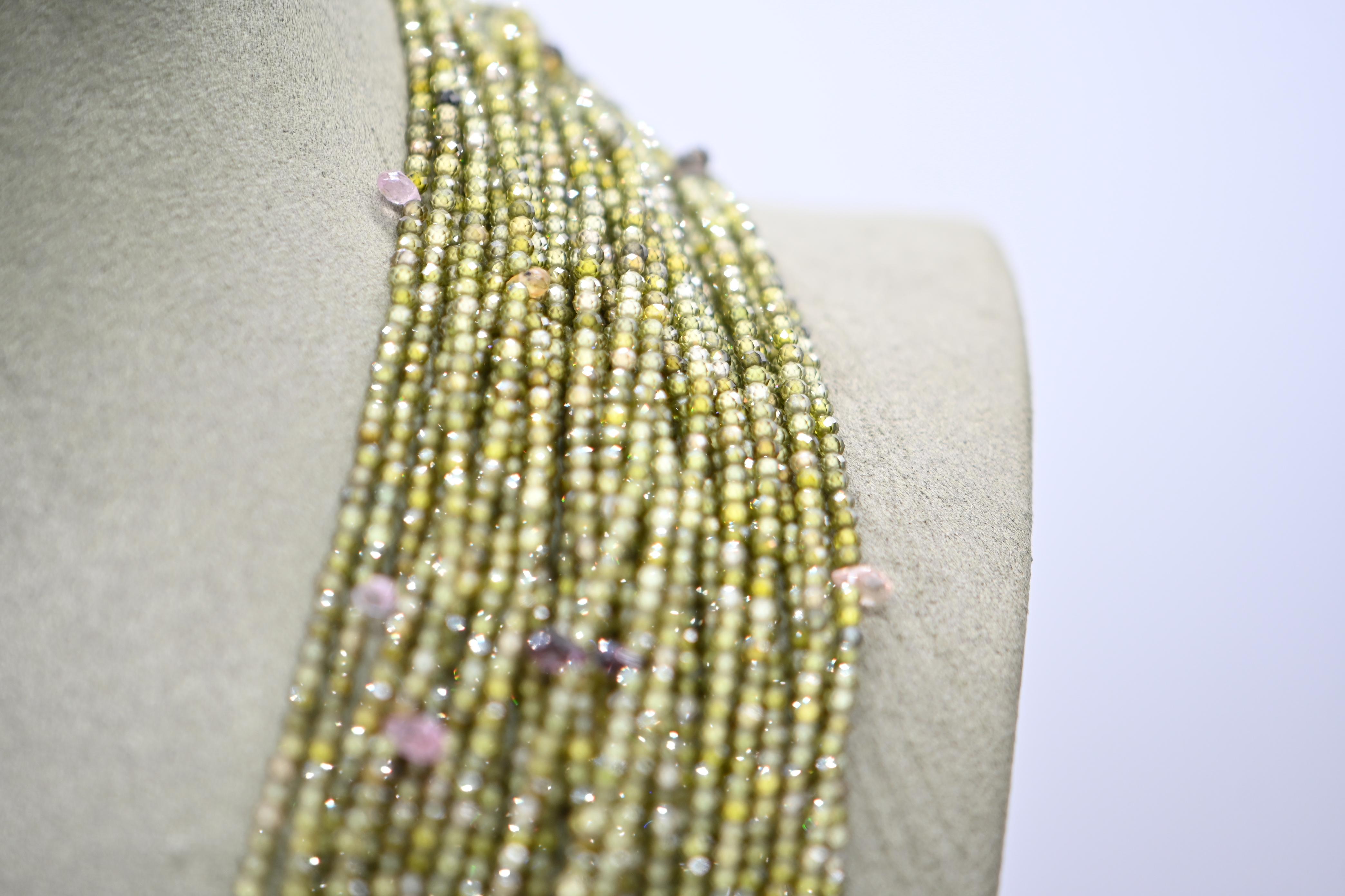 Green Zircon and Sapphire Multi-Rank Necklace with Bakelite Clasp

This sumptuous multi-strand necklace is composed of 30 strands of green zirconia and sapphire pearls, bringing captivating nuances and natural sparkle. The rows of pearls, of