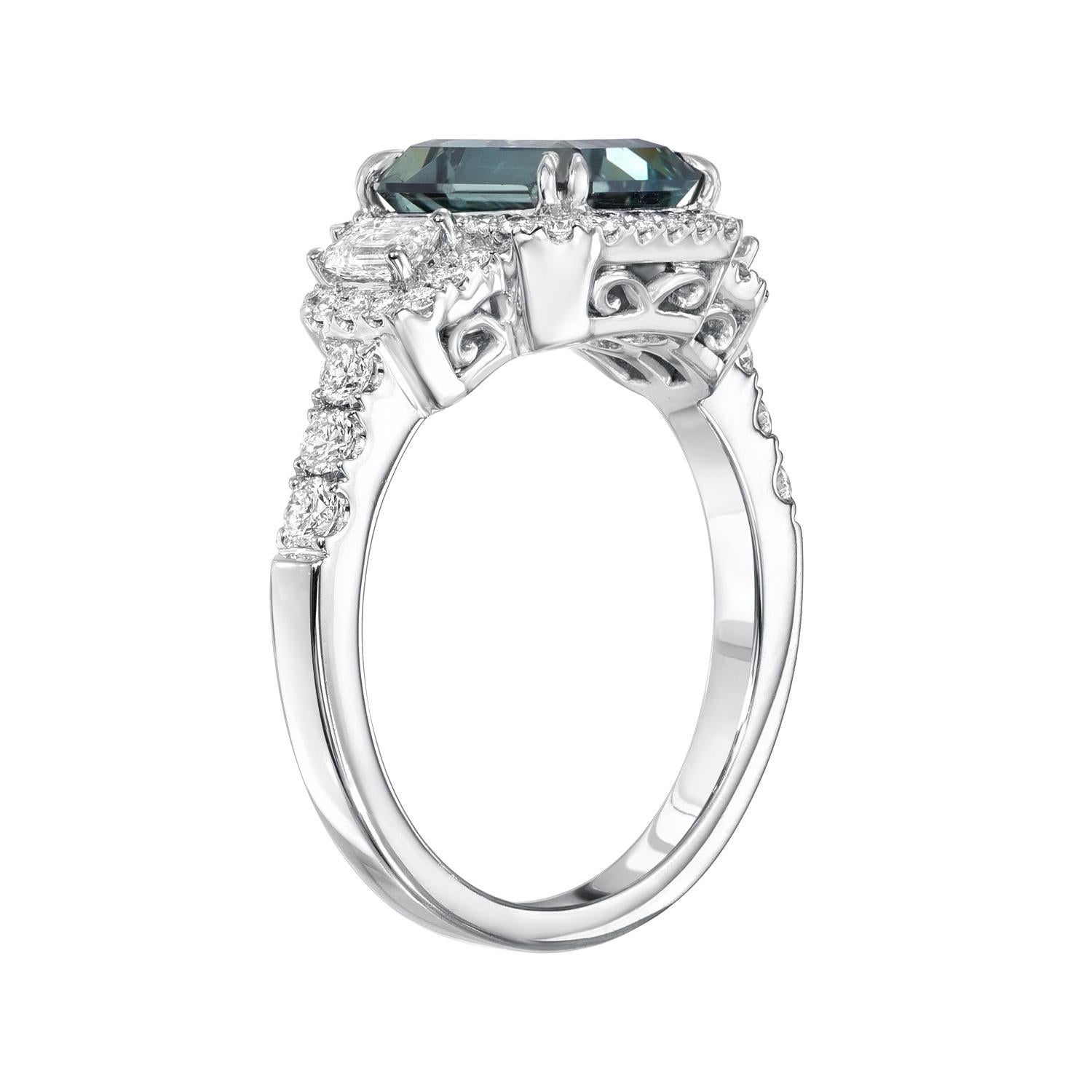 Special 2.92 carat Teal Sapphire emerald-cut, 18K white gold ring, flanked by a pair of emerald-cut diamonds and round brilliant diamonds weighing a total of 0.77 carats. 
Ring size 6.5. Resizing is complementary upon request.
Crafted by extremely