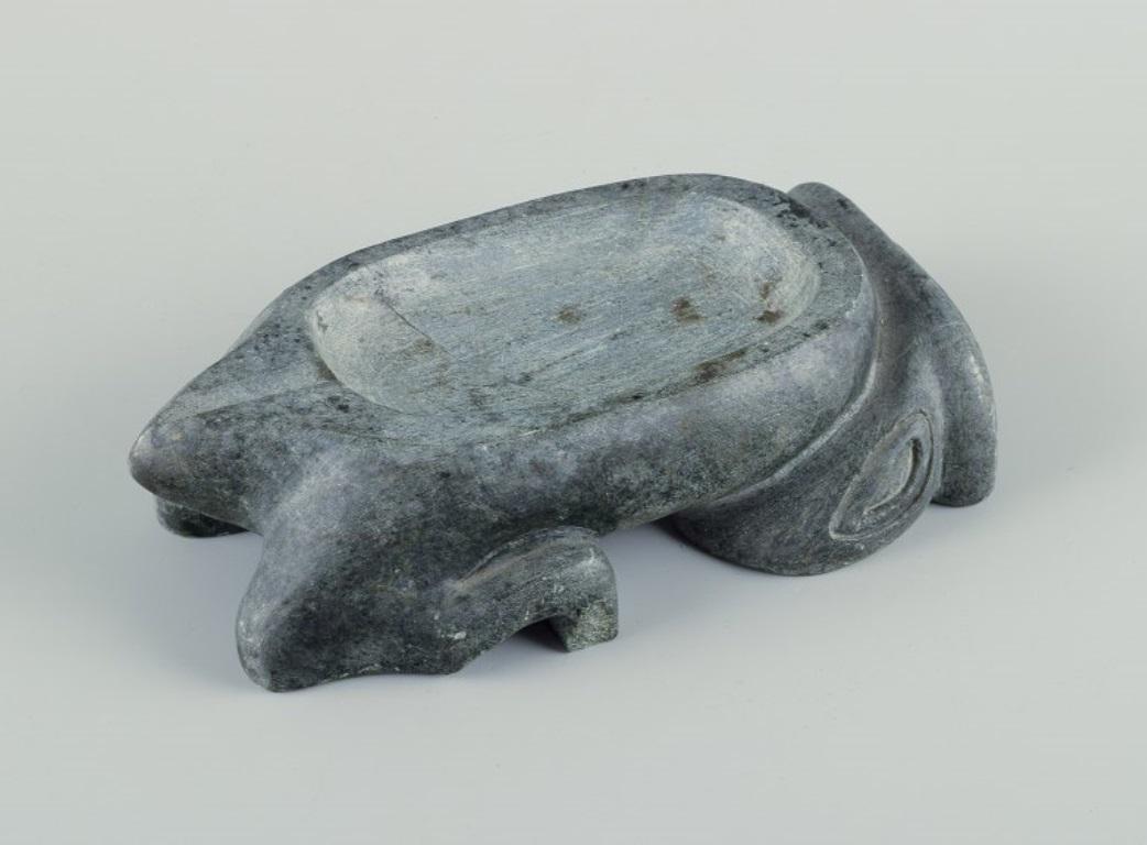 Greenlandica, scultura in pietra ollare. Ciotola a forma di creatura mitica.
Groenlandia.
Approssimativamente dagli anni '60.
In ottime condizioni, con una piccola scheggiatura sulla base.
Dimensioni: L 17,0 cm x L 9,0 cm x H 4,5 cm.