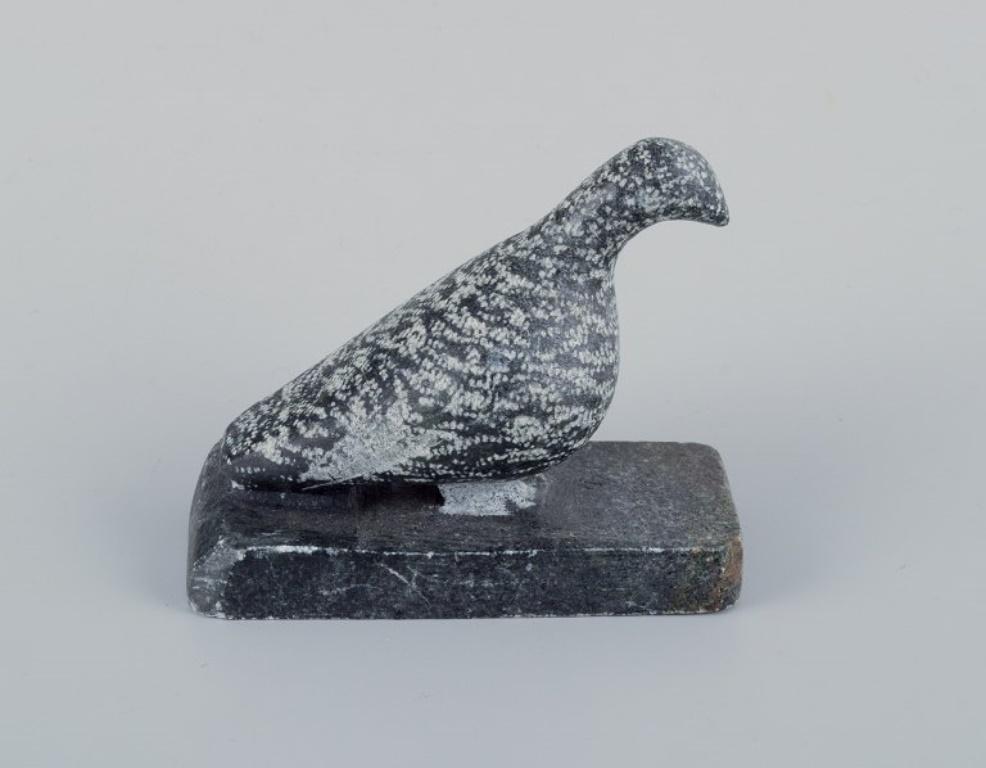 Greenlandica, three pieces of soapstone and a black pouch with a keyring. 
Features a ptarmigan, seal, and hunter.
Artists : Nem Paamiut, Josef Josefsen.
Signed 76 (ptarmigan) and 2000 (hunter).
In excellent condition.
Hunter: H 12.8 cm x D 4.3 cm.