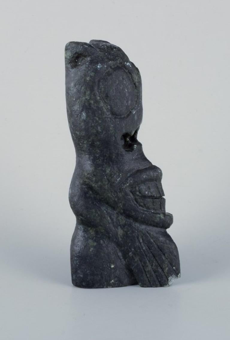 Greenlandica, Tupilak. 
Traditional, magic Greenlandic figurine carved in soapstone.
Greenland mid-20th century.
In good condition, with damage to the base (see photo).
Dimensions: H 12.8 cm x W 5.5 cm.
Soapstone - also known as Steatite - is a