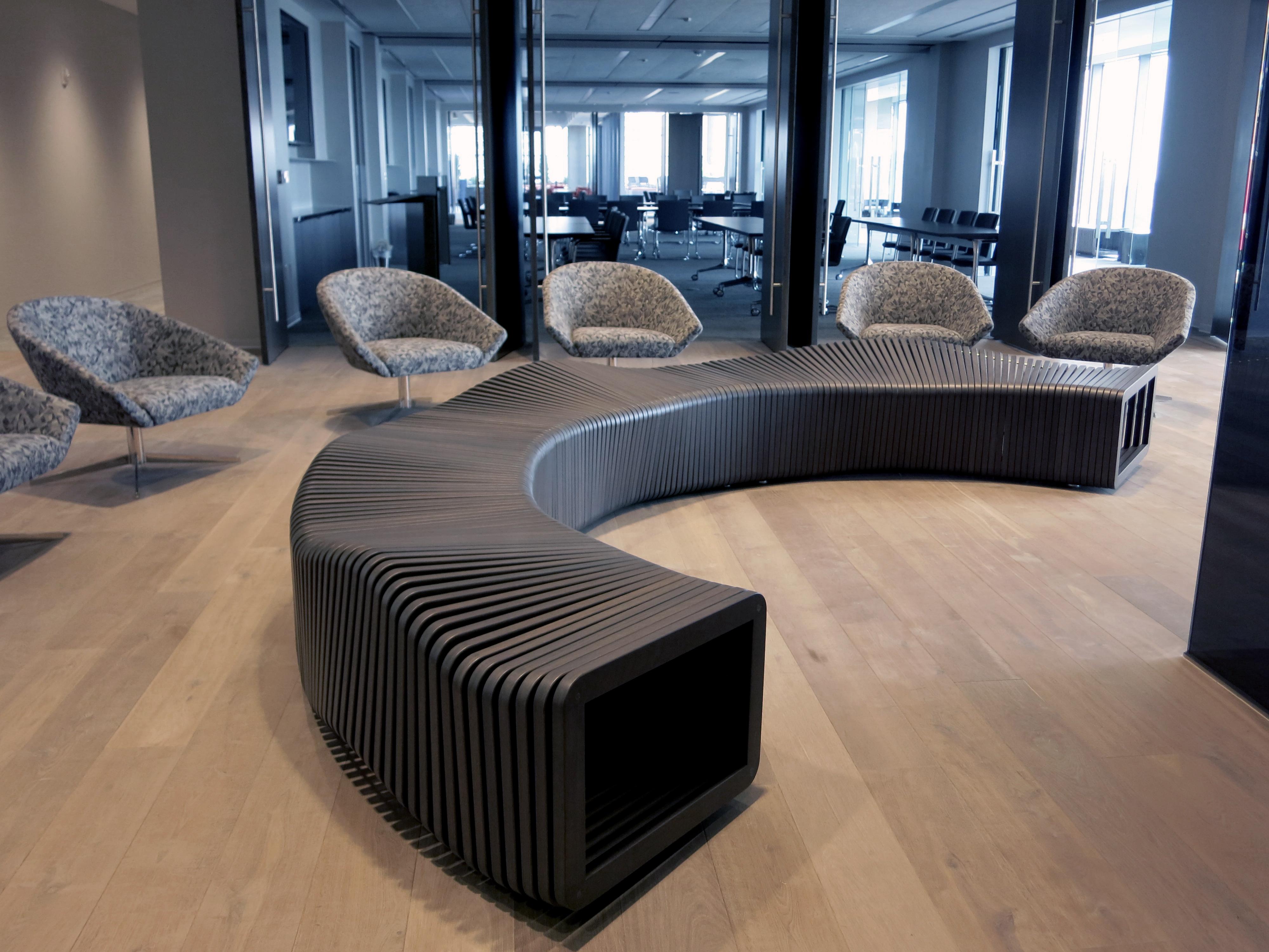 Rectangular frames and held together with fasteners and brass spacers to create an undulating serpentine bench. One half circle is created by five separate pieces allowing for various configurations. 

Available in most domestic woods. Custom