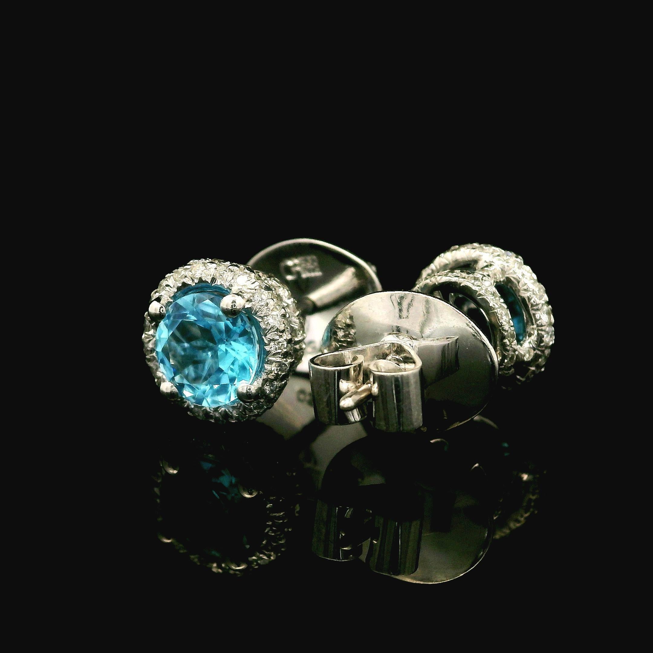 –Stone(s)–
(2) Natural Genuine Topaz - Round Brilliant - Prong Set - Vivid Blue Color - 6mm (approx.) -2ctw (approx.)
(Numerous) Natural Genuine Diamonds - Round Brilliant - Pave Set - White and Fiery - 0.30ctw (approx.)

Material: 18k White Gold