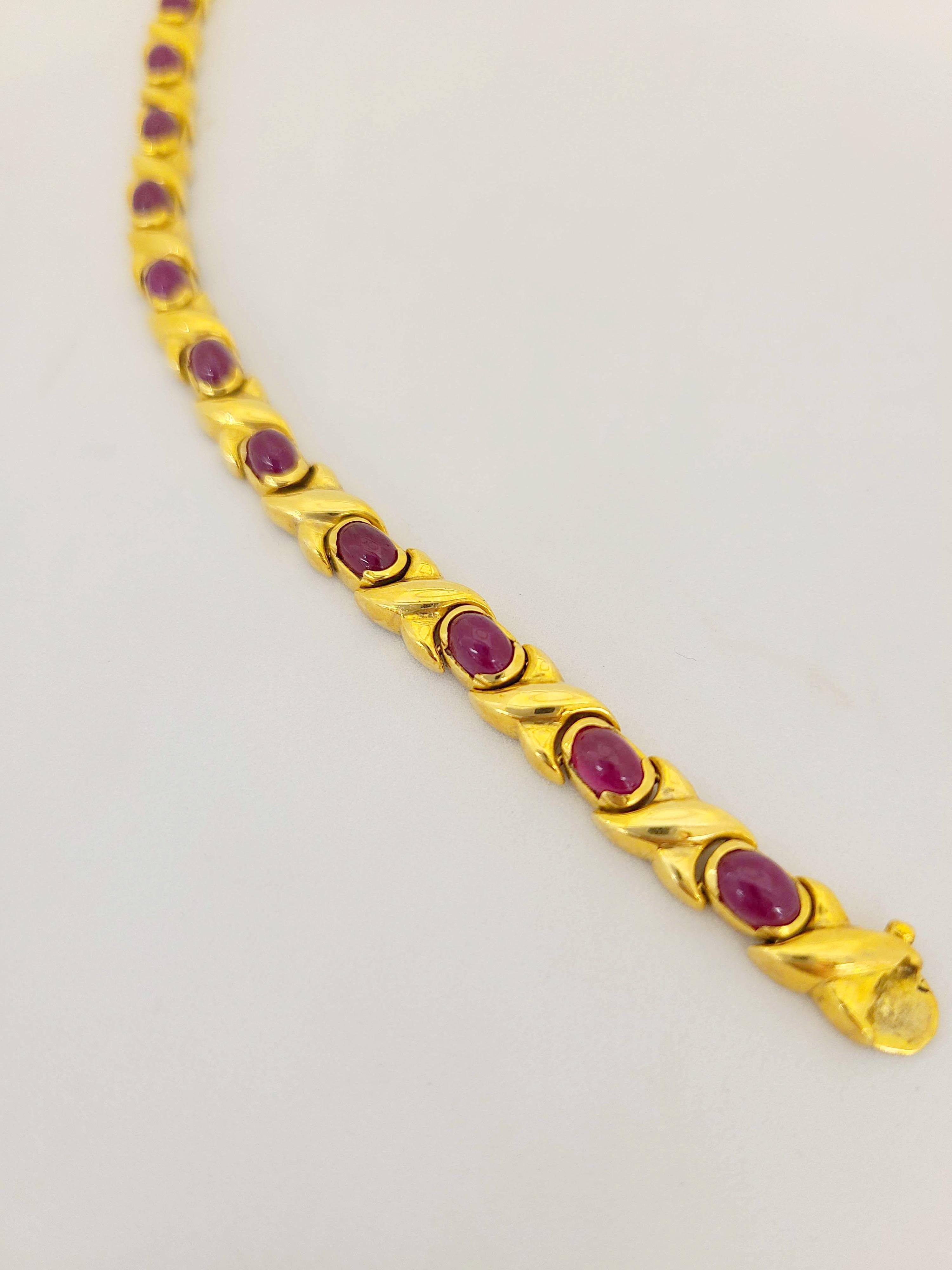 Classic line bracelet designed in 18 karat yellow gold set with 14 cabochon oval rubies. The rubies are bezel set and alternate with a gold crisscross link. The bracelet measures 7.5
