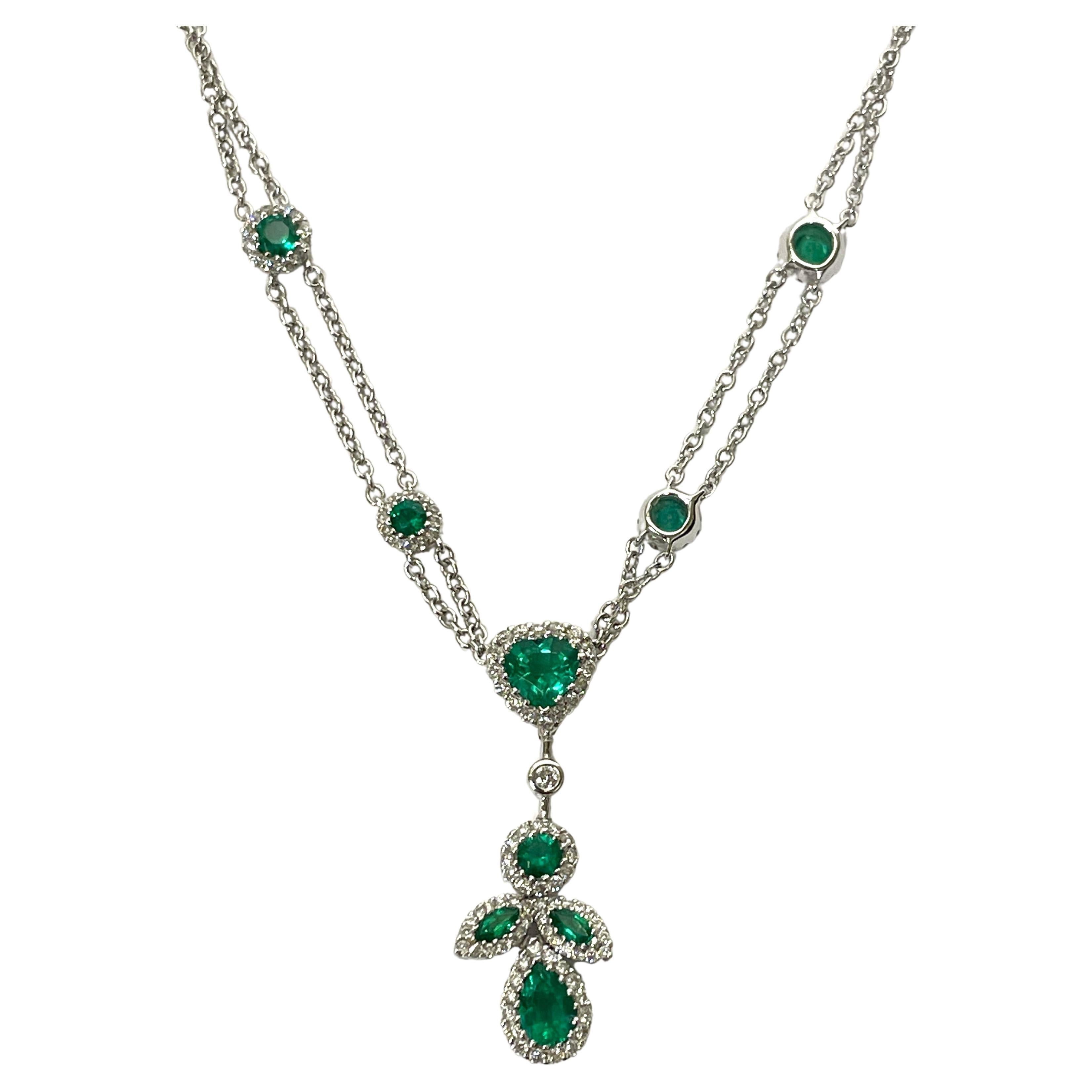 By New York designer Gregg Ruth, this stunning emerald and diamond necklace is sure to grab attention!  Absolute beauty!
18 karat white gold double cable chain.
Four round emeralds with halos of diamonds adorn the necklace chain.
An emerald heart,