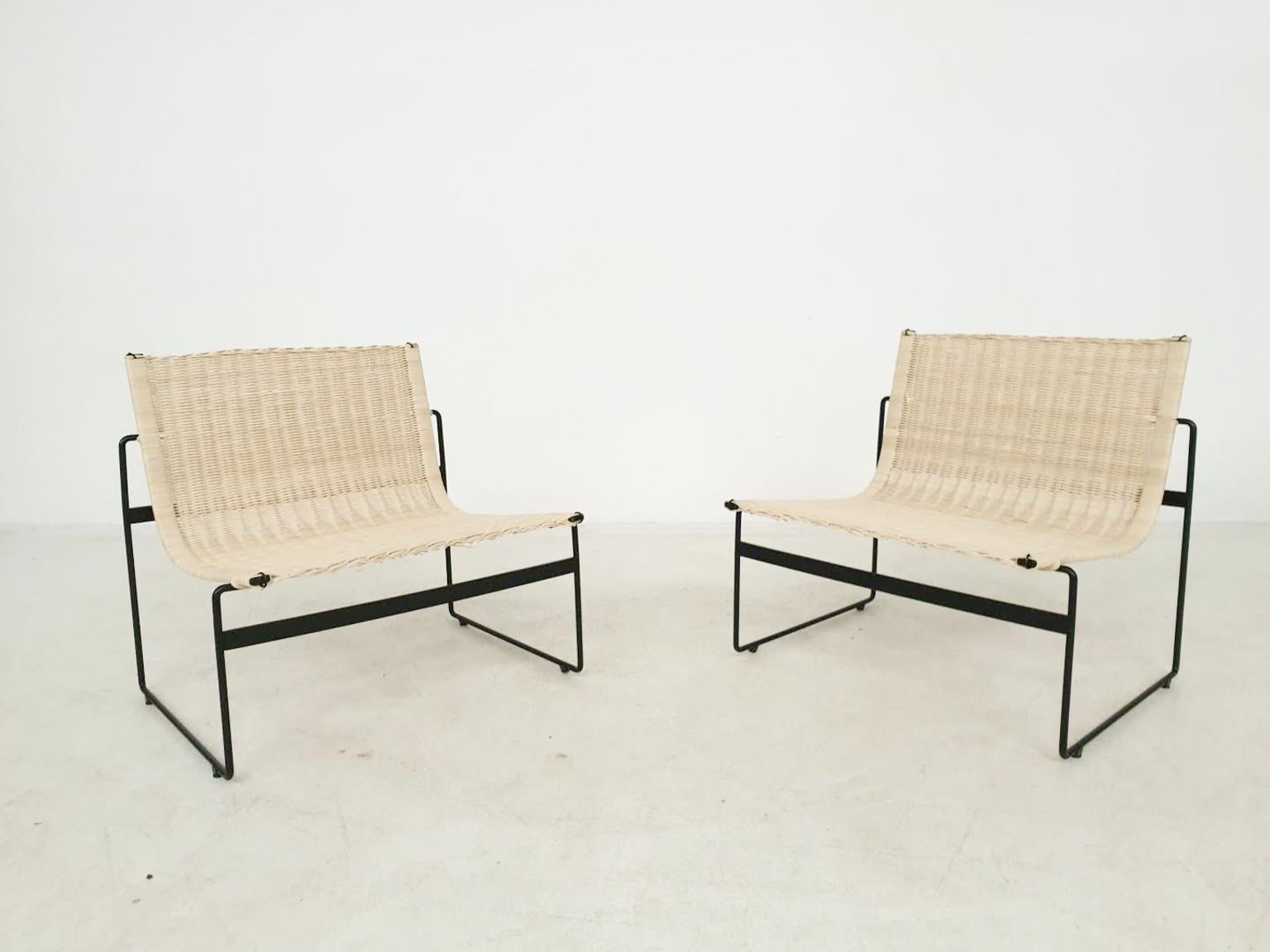 Very rare pair of black metal lounge chairs with rattan seatings, designed by the Spanish Gregorio Vicente Cortes and Luis Onsurbe. Sold in the Netherlands by the legendary department store Metz and Co in 1961. 

This lounge chair is made of a