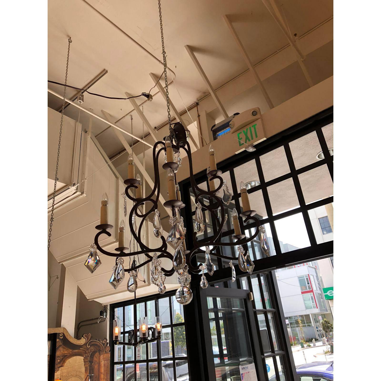 A Rousseau chandelier with crystals by Gregorius Pineo. The frame is hand-forged Iron with six arms with crystals. Consist of twelve lights wired with UL approval for candelabra base bulbs, 25 watt max each. There are waxed covered candle sleeves.