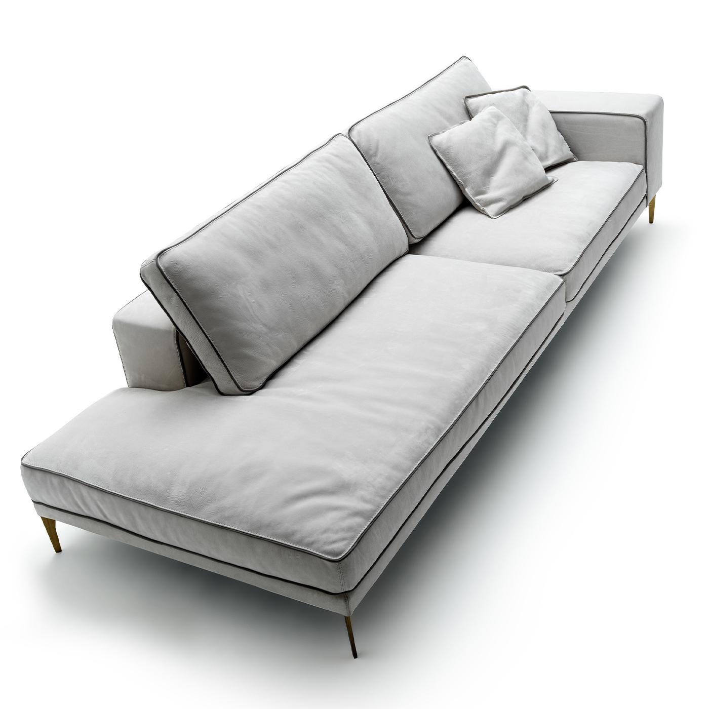 A clean and essential design marked by soft and embracing lines, this sofa was designed by Castello Lagravinese Studio. Its welcoming silhouette rests on metal feet boasting a satin brass finish, and is exquisitely upholstered of white Grassé