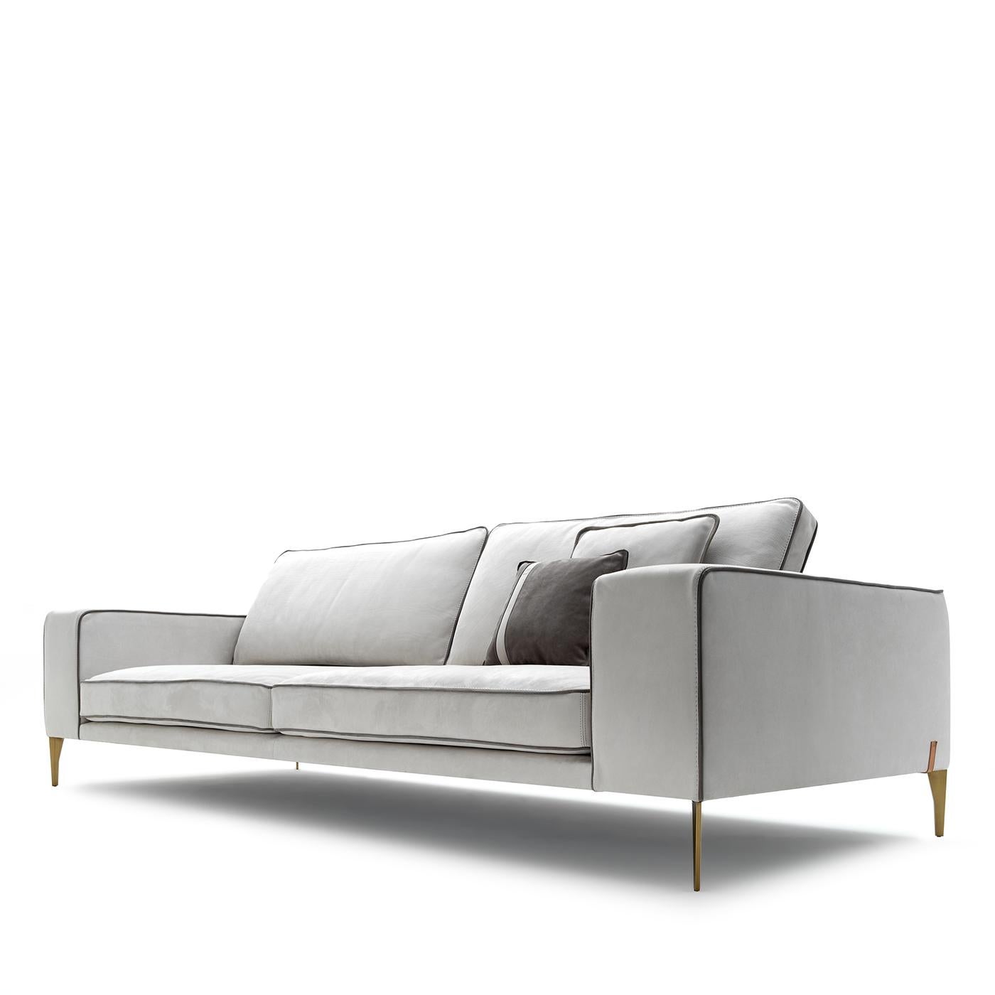An elegant and clean design by Castello Lagravinese Studio, this sofa boasts a pure white tone that will make a refined statement in any modern decor. Resting on sturdy metal feet marked by a satin brass finish, it is upholstered of soft and velvety
