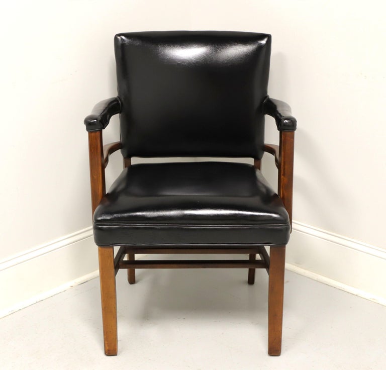 A vintage Traditional style office side chair by Gregson Manufacturing, of Liberty, North Carolina, USA. Solid walnut frame with black faux leather (vinyl) upholstery, square back, black nailhead trim, straight square legs and stretchers. Made in