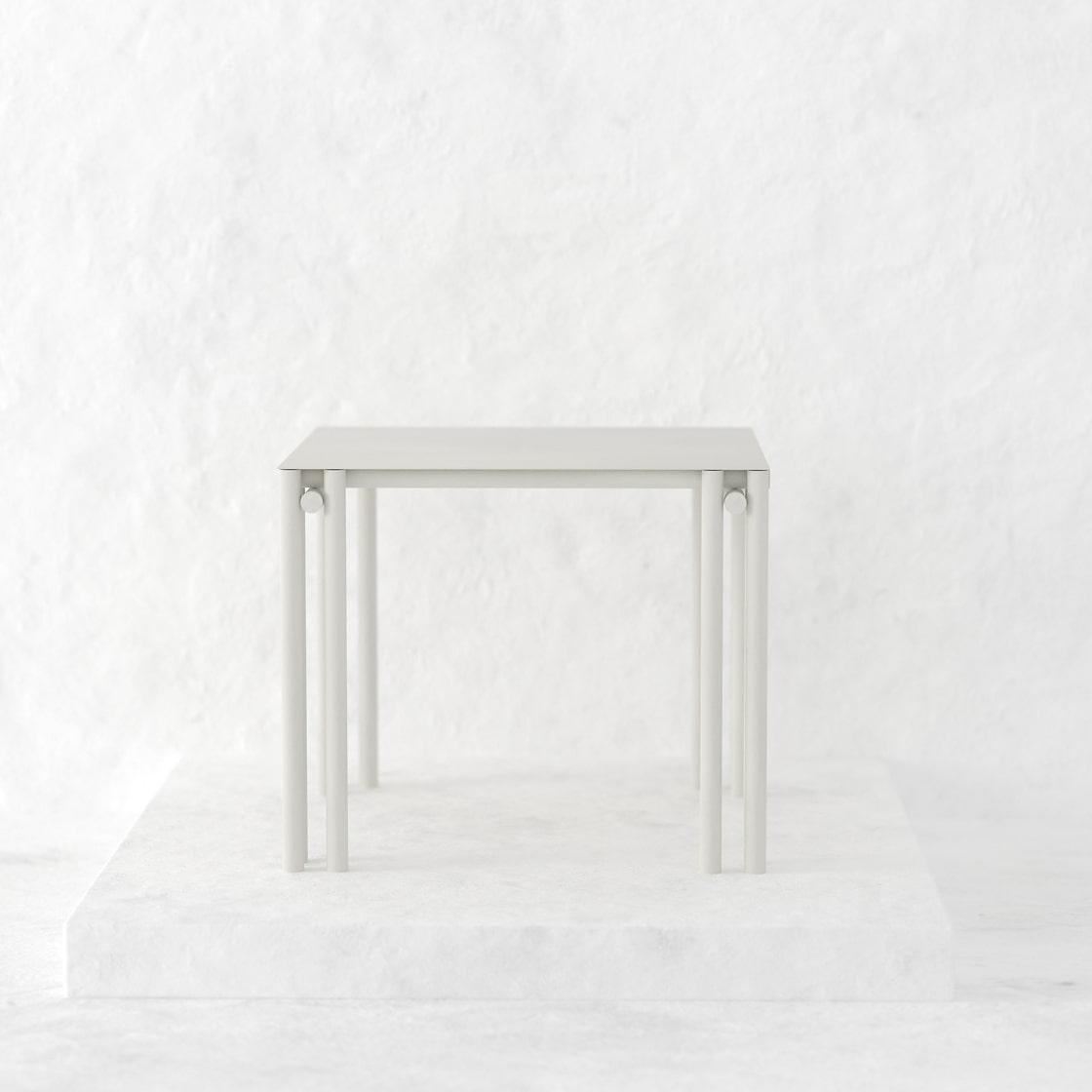 La table à manger carrée Dolmen est une pièce tubulaire conçue comme une table à manger convenant aussi bien à l'intérieur qu'à l'extérieur. 
Fabriquée à la main en métal et revêtue d'une finition électrostatique mate, sa taille peut être