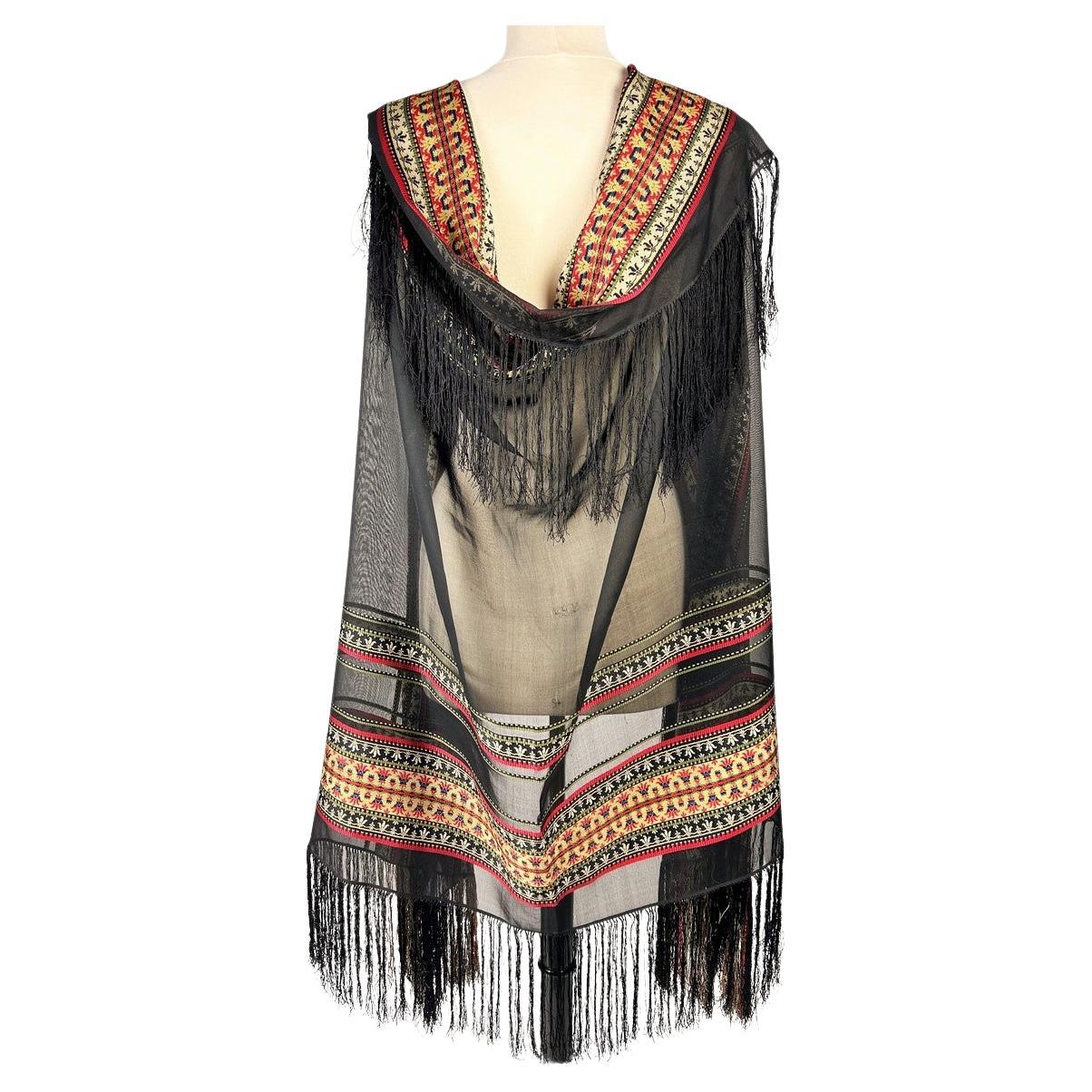 Circa 1860
Francia

Scialle rettangolare da indossare come stola, in seta grenadina straordinariamente trasparente, probabilmente realizzato a Lione o Saint-Etienne durante il Secondo Impero francese. Seta nera rigida (simile all'organza) tessuta