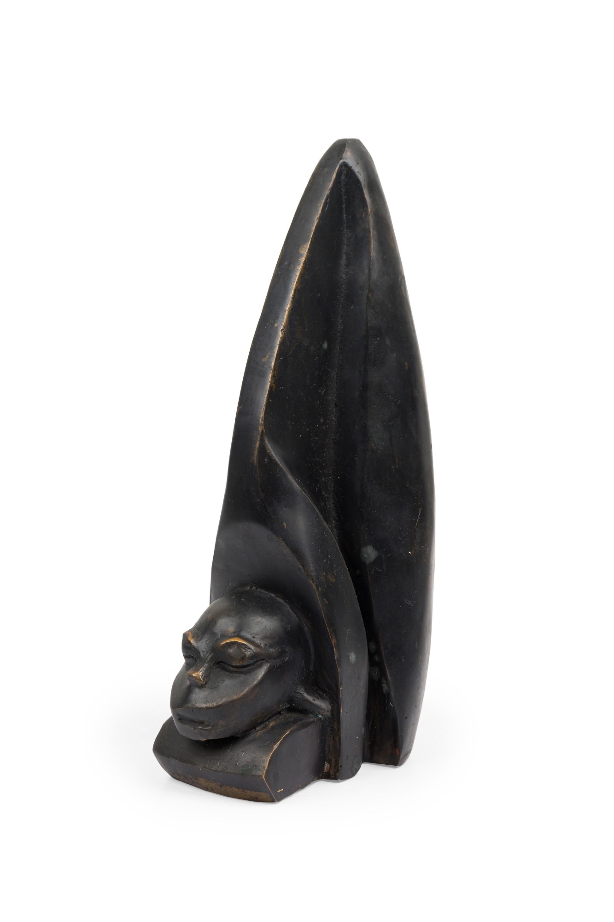 Contemporary hand-forged bronze Brutalist-inspired figural sculpture finished in an ebonized patina depicting a human head carved into a large animal\'s tooth. (PRICED EACH) (