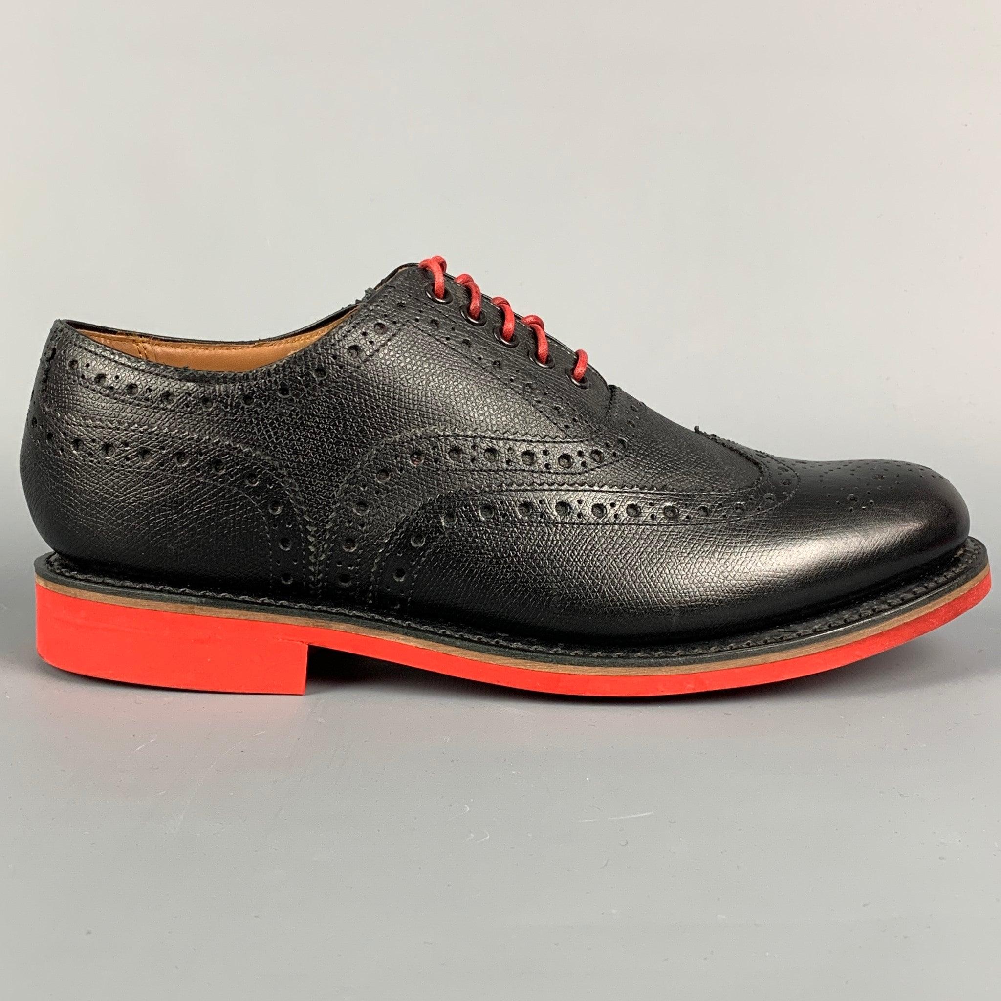 GRENSON shoes in a black perforated leather featuring a wingtip style, red rubber sole, and a lace-up closure. Includes box.
Excellent
Pre-Owned Condition. 

Marked:   5033 450RD 8.5 G Outsole: 11.5 inches  x 4 inches 

  
  
 
Sui Generis