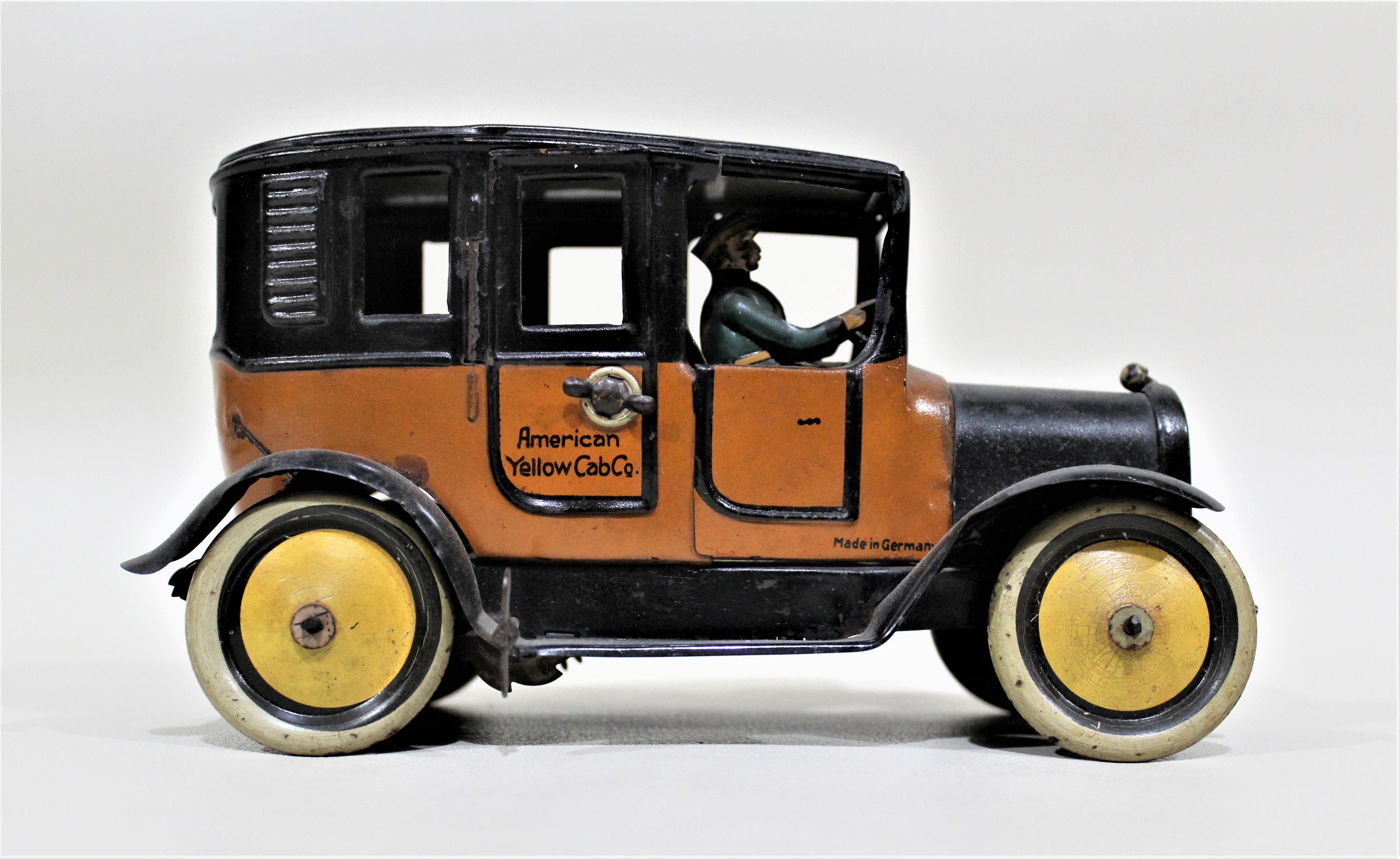This tin toy 'Yellow Taxi' was most likely made by the German toy manufacturer, Greppert & Ketch during the 1930s. The toy is a period sedan complete with a driver, latching doors and tension spring style motor. This German tin toy is in nice period