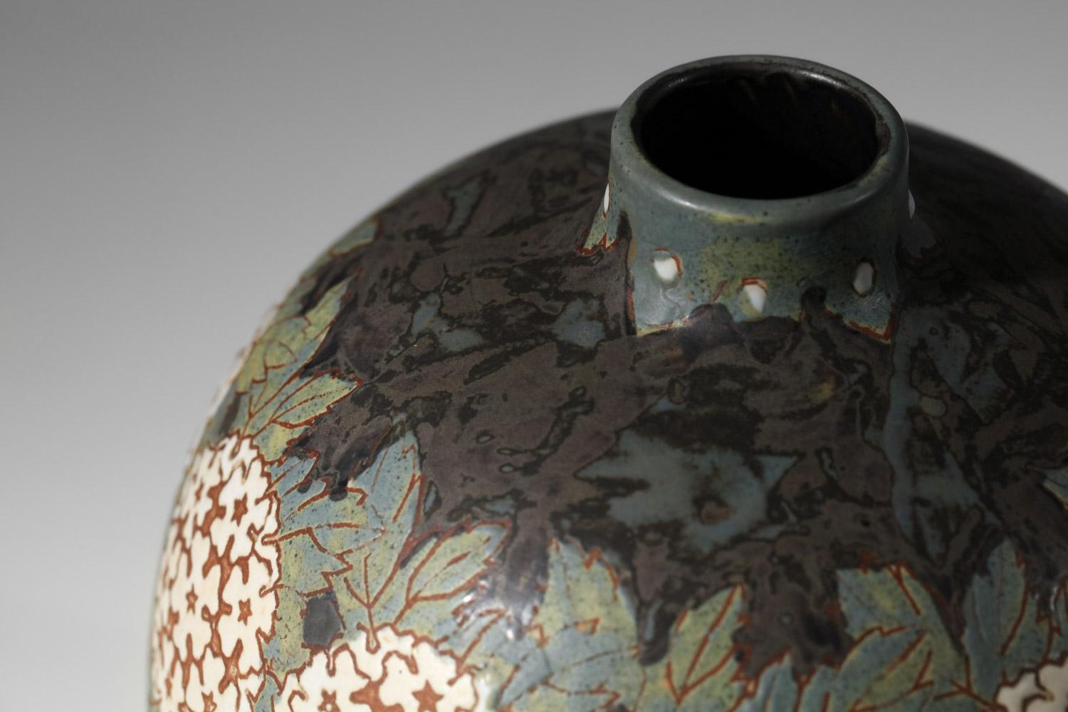 Vase boule en céramique des années 1940 du fabricant belge Grès Keramis. Joli vase décoré d'une frise d'hortensias blancs et de feuillages dans les tons verts et bruns. Très bel état vintage, avec de légères traces d'âge et d'utilisation (voir