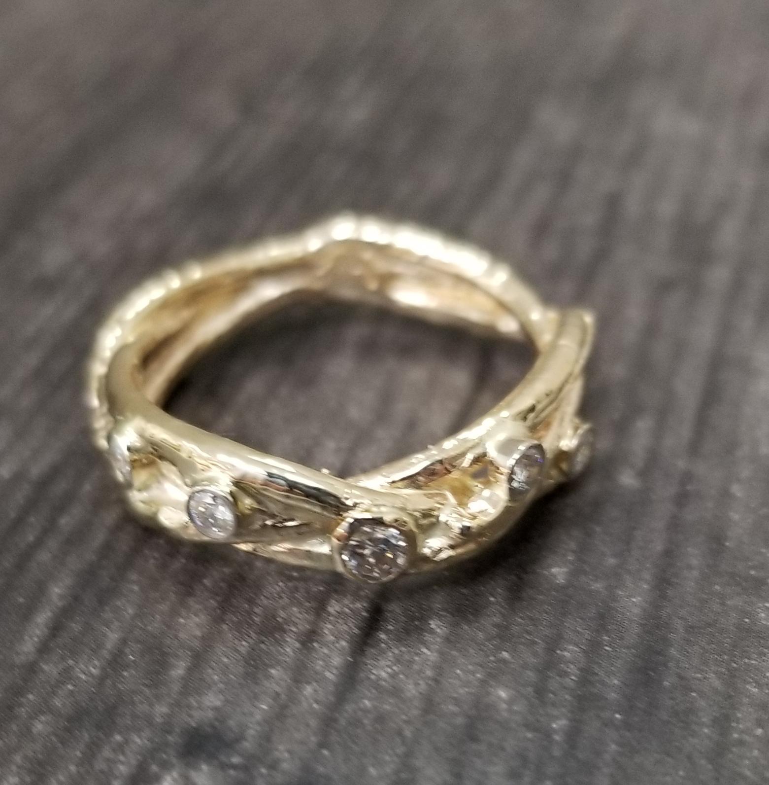 14k yellow gold Gresha signature bark design woven diamond wedding ring, containing 5 round full cut diamonds of very fine quality weighing .20pts. set in 14k white gold bezels.

*this design is ours and can be created in any other form; ring,
