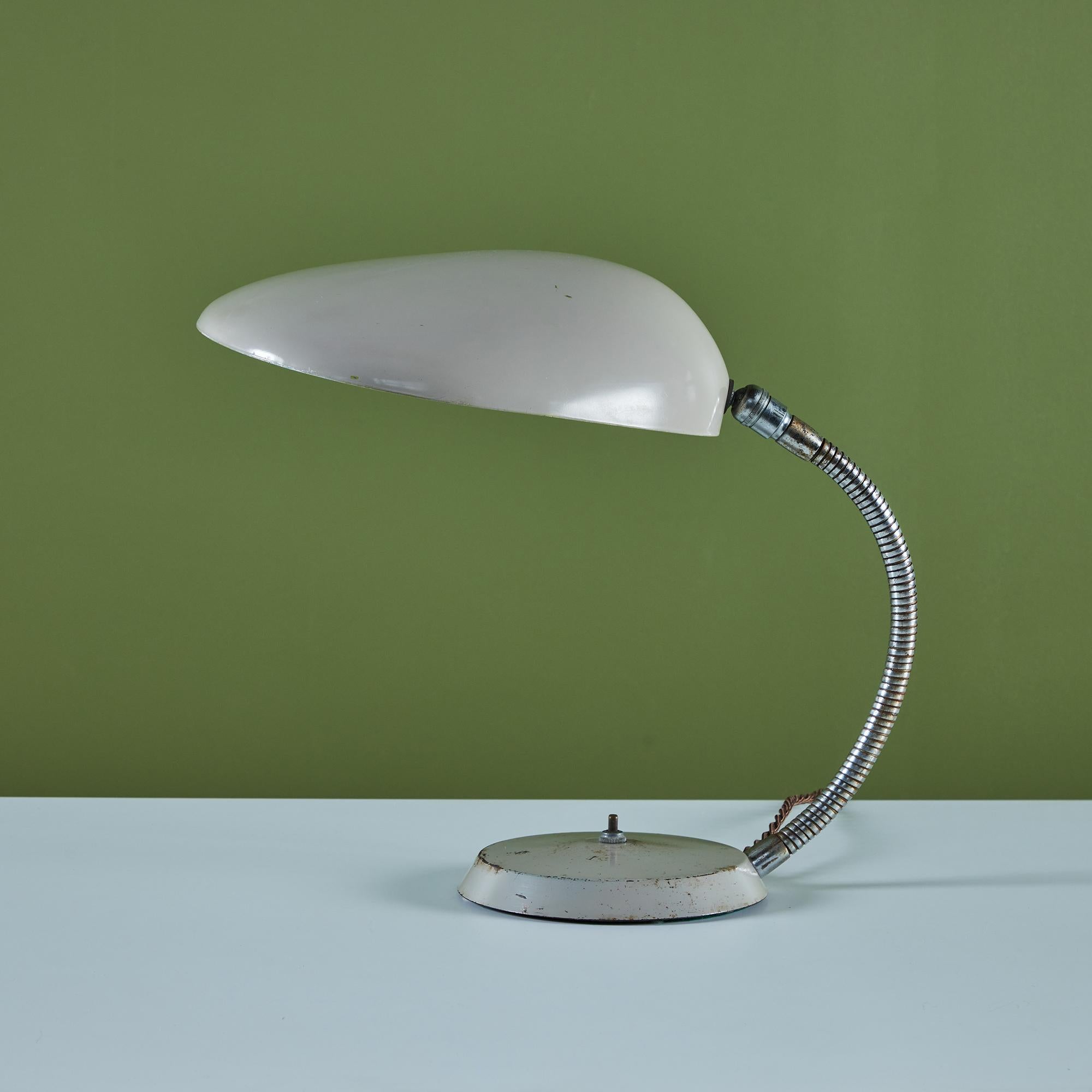 An award-winning 1948 design by Swedish-American Greta Grossman for Ralph O. Smith, a California-based lighting company. The lamp, colloquially known as the “Cobra” for its uniquely shaped cement colored enamel shade that resembles a cobra’s hood,