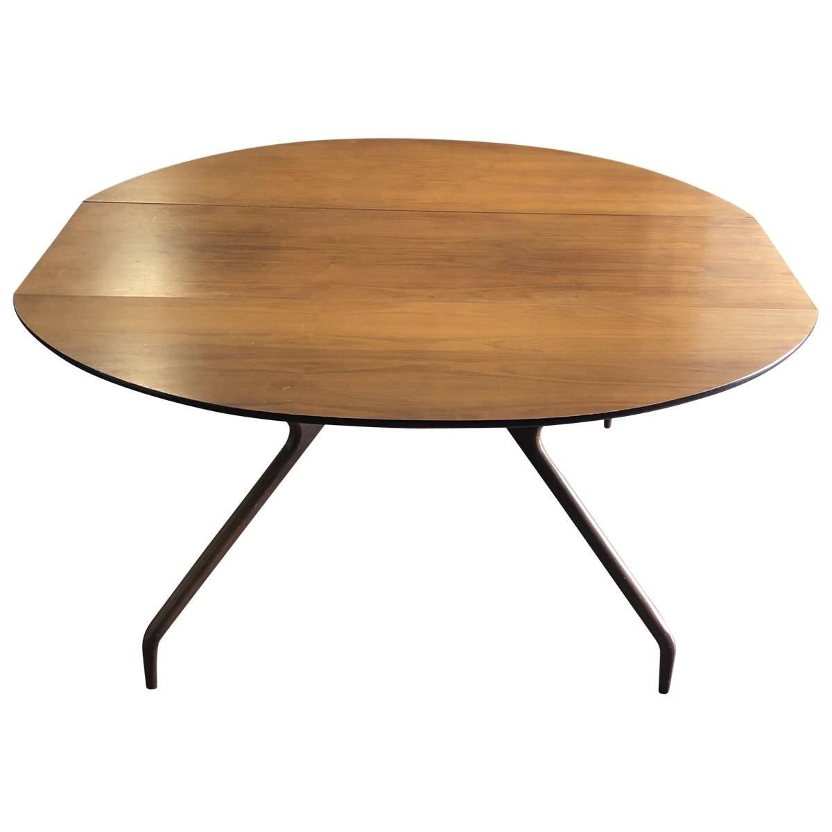 Sleek and shapely, this eye-catching drop-leaf dining table features sculptural spider-like legs that pullout / pull-out to support extended leaves. Designed by Greta Grossman for Glenn of California, this gorgeous drop-leaf dining table brings