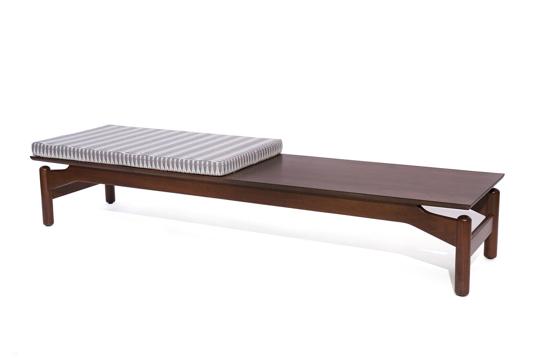 Greta Grossman for Glenn of California walnut and upholstered bench or coffee table, circa early 1960s. This example has been newly finished and newly upholstered in a light grey pattern.