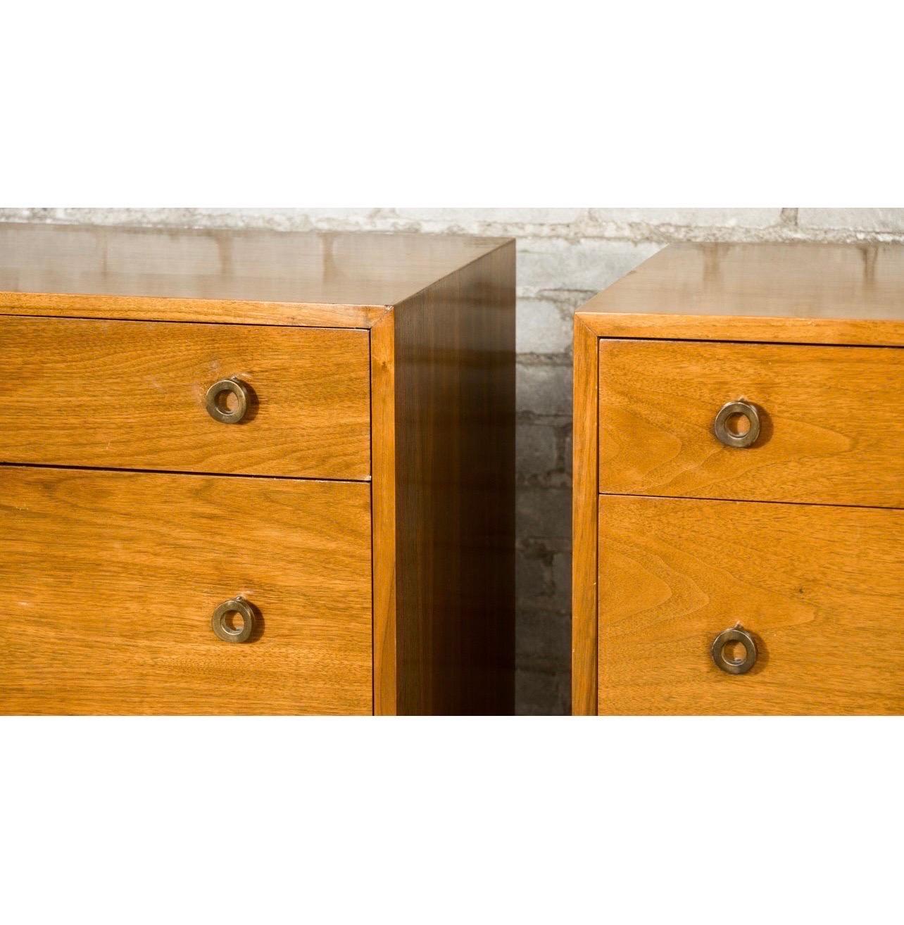 Gorgeous pair of lowboy dressers designed by Greta Grossman for Glenn of California, circa 1950's. Elegant walnut wood grain contrasts perfectly with signature Grossman round brass pulls. Each dresser features 3 drawers with divider in bottom