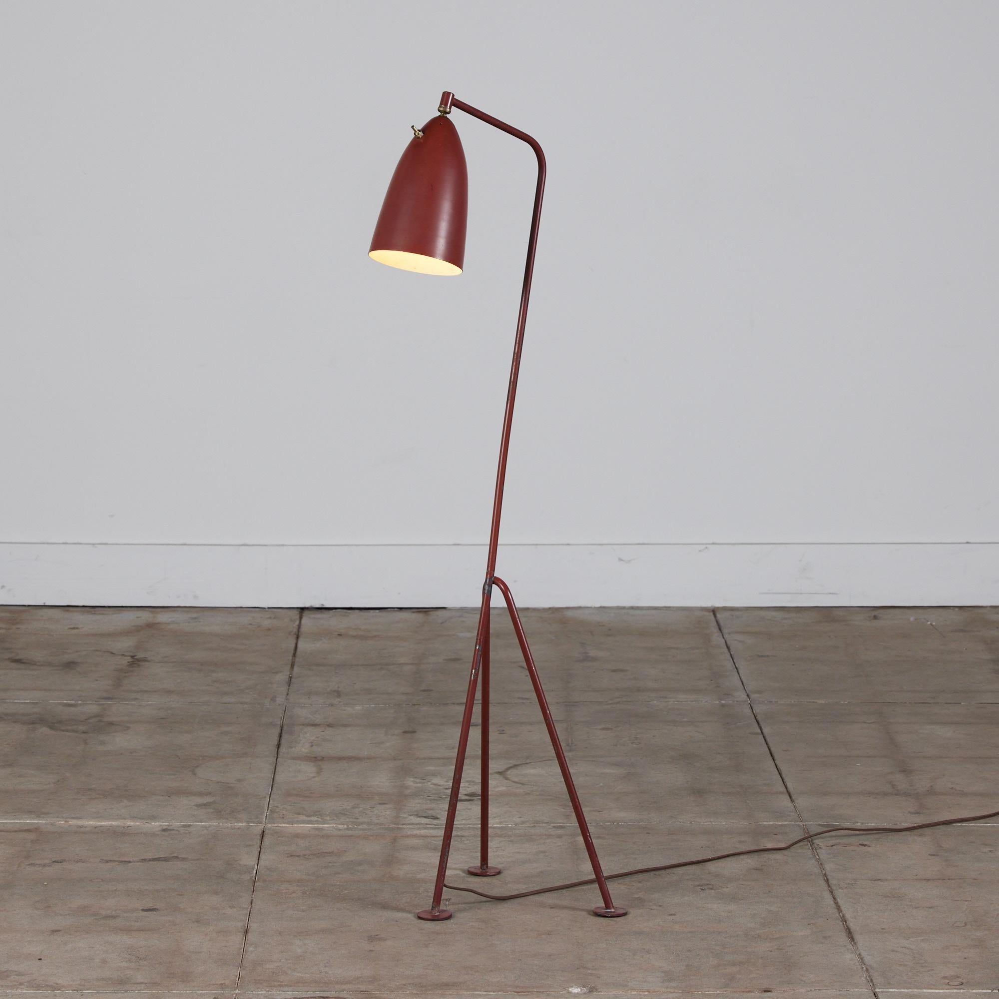 Designed by Swedish-American designer Greta Grossman for Ralph O. Smith, c.1947, USA. The lamp offers a minimalist design with a brick red enameled metal body. The cone shaped spun aluminum shade pivots allowing for directional lighting. The lamp