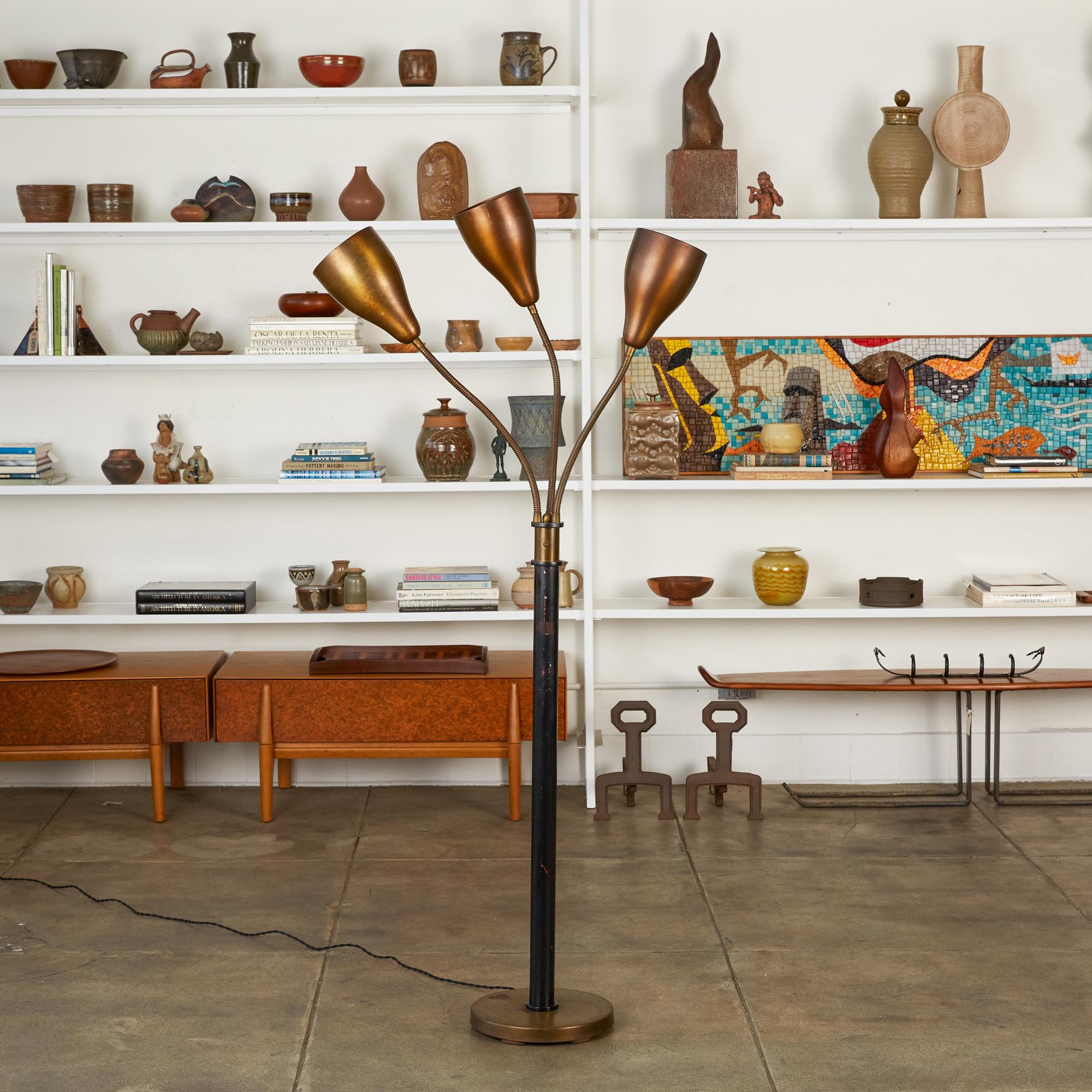 Greta Grossman style three headed floor lamp by Los Angeles Modernist lighting brand Marbro Lamp Company, circa 1950s. The lamp features three articulating gooseneck arms with spun steel cone shades that are attached to a black painted metal stem