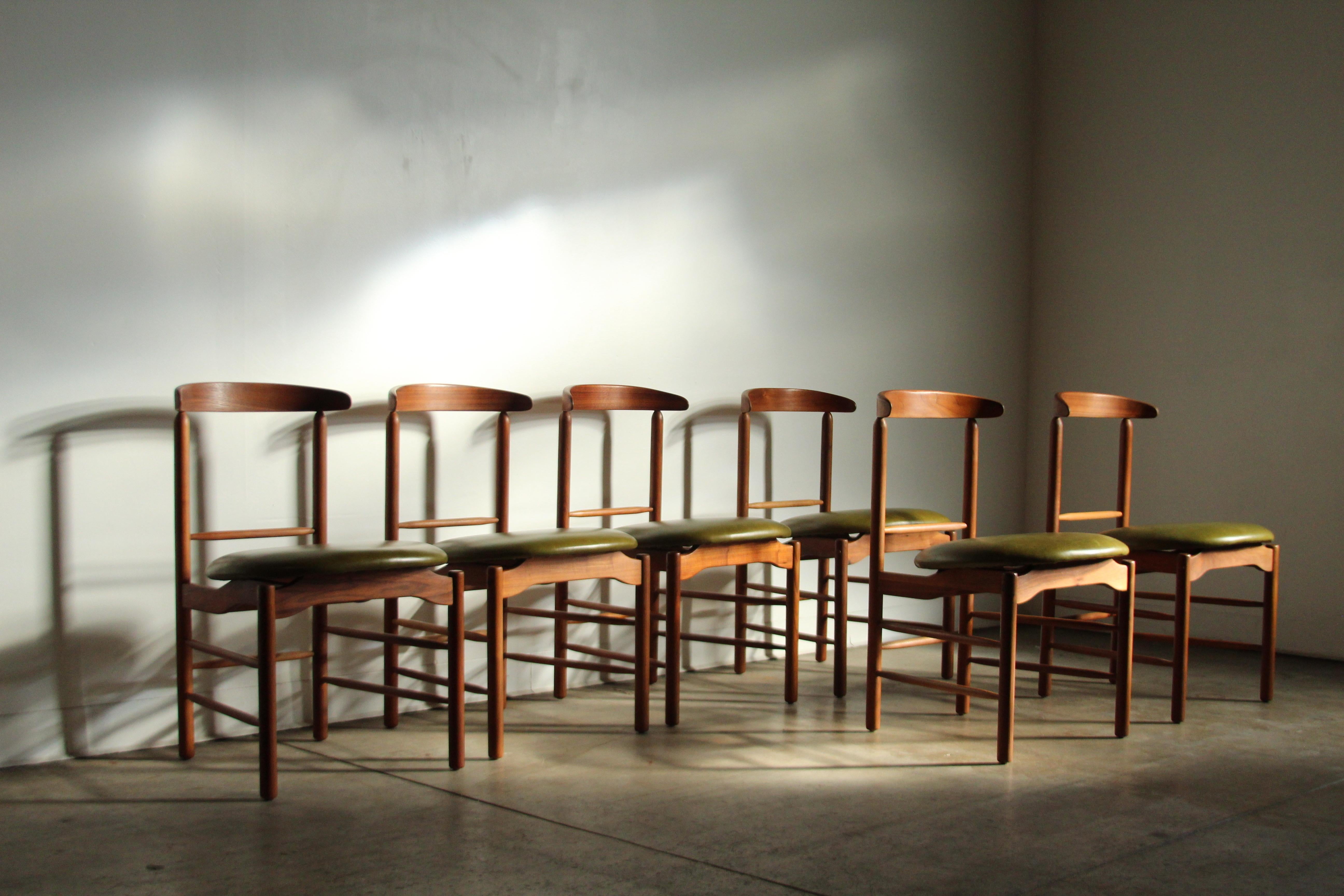 A wonderful set of dining chairs by Greta Grossman for Glenn of California circa 1950s. The set is composed of six solid walnut sculpted chairs with gently curved backs and floating seats. The seats are upholstered in a lightly distressed, moss