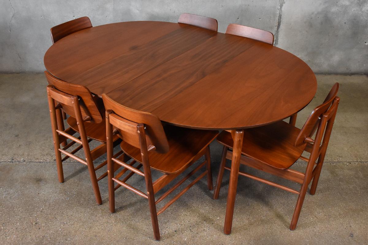A beautiful set designed by Greta Grossman for Glenn of California. Includes table with two leaves and six chairs. The table features Grossman's classic leg design as also seen on the series of consoles and coffee tables designed for Glenn. The