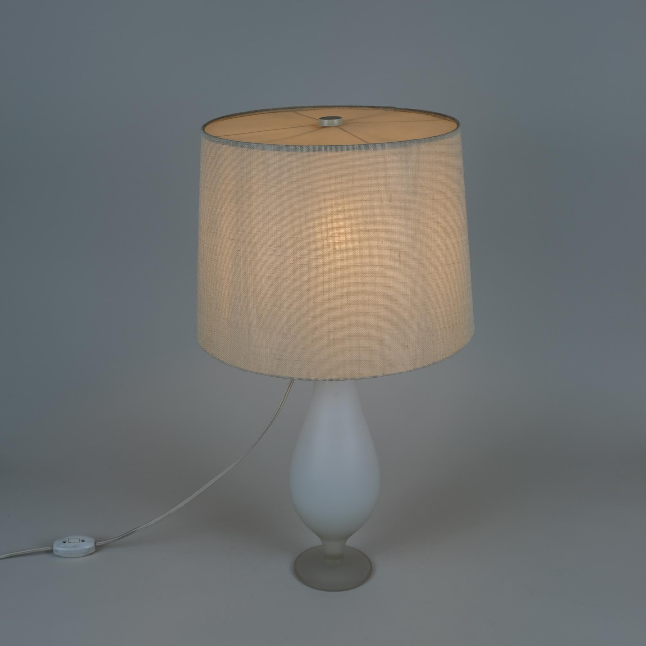 A beautiful lamp by renowned Finnish designer Greta Lisa Jäderholm-Snellman in frosted glass, brass and brass top with a linen / plastic shade. The lamp is quite elegant and suitable for classic interiors as well as modern ones. It is signed to the